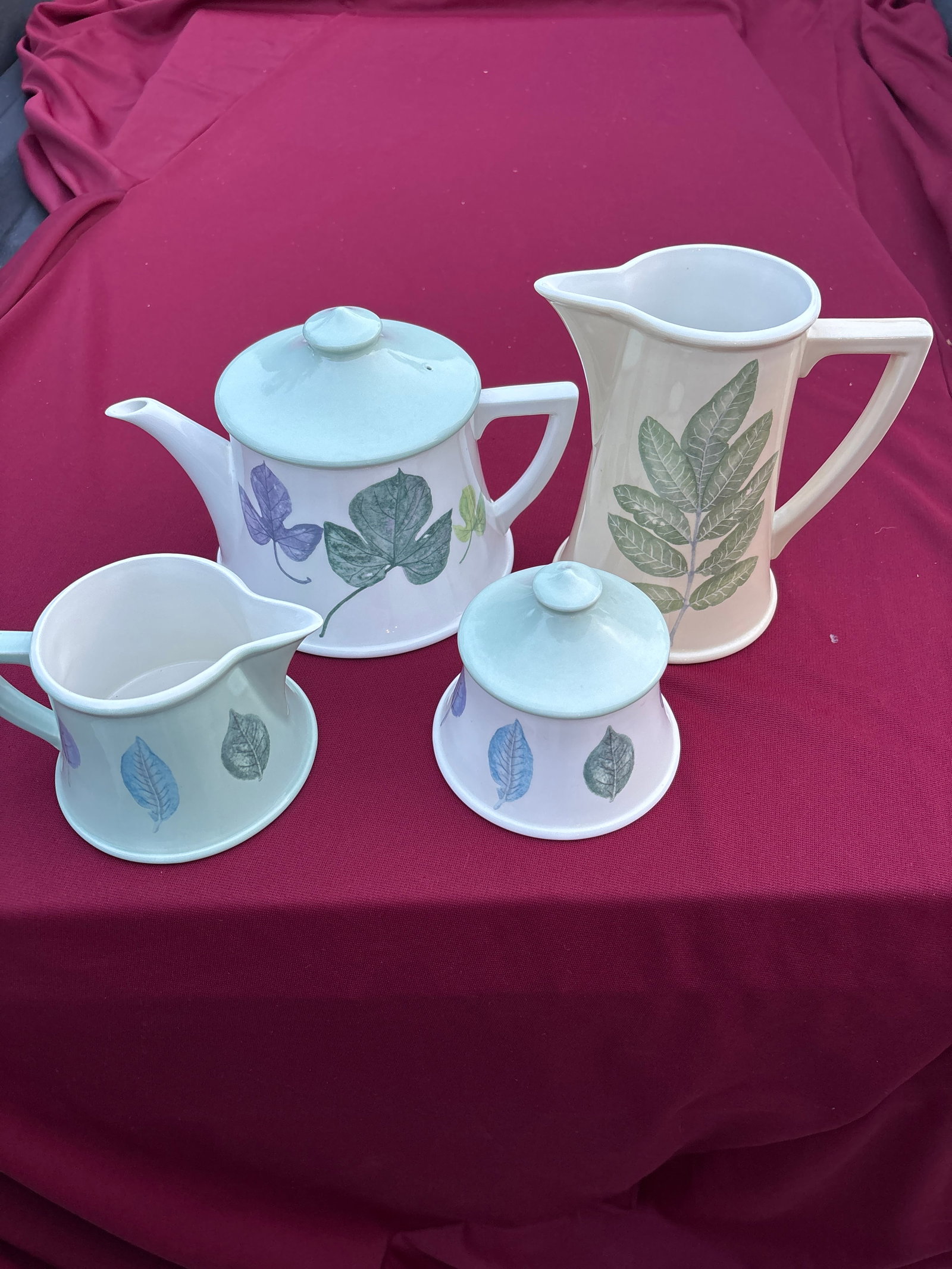 Four piece Portmeirion "Seasons Leaves" teapot , creamer, lidded sugar bowl & jug: Portmeirion "Seasons Leaves" teapot , creamer, lidded sugar bowl & jug designed by Anwyl Cooper-Willis.Design: The earthenware pieces feature various embossed leaf patterns.Origin: These items were ma