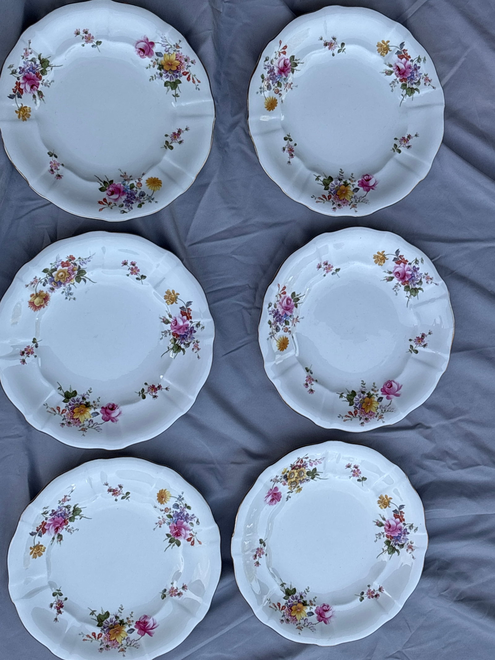 Set of six Royal Crown Derby Derby Posies 8&1/2 inch plates: Set of six Royal Crown Derby Derby Posies tea or dinner plates featuring a floral pattern and scalloped edges.Material: Fine bone china crafted in England.Design: Distinctive scalloped edge with vibra