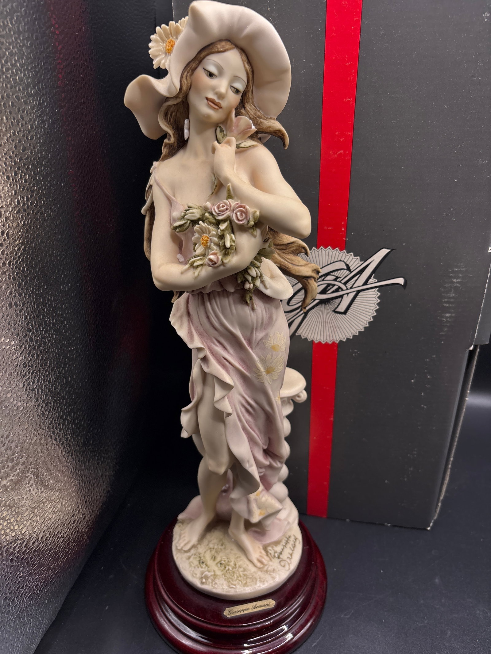 vintage Giuseppe Armani "Daisy" figurine, a 1994 event piece: With box…Giuseppe Armani "Daisy" figurine, a 1994 event piece featuring a lady in a hat with flowers.It is a porcelain figure from Florence, Italy, typically measuring around 15 inches tall.Values