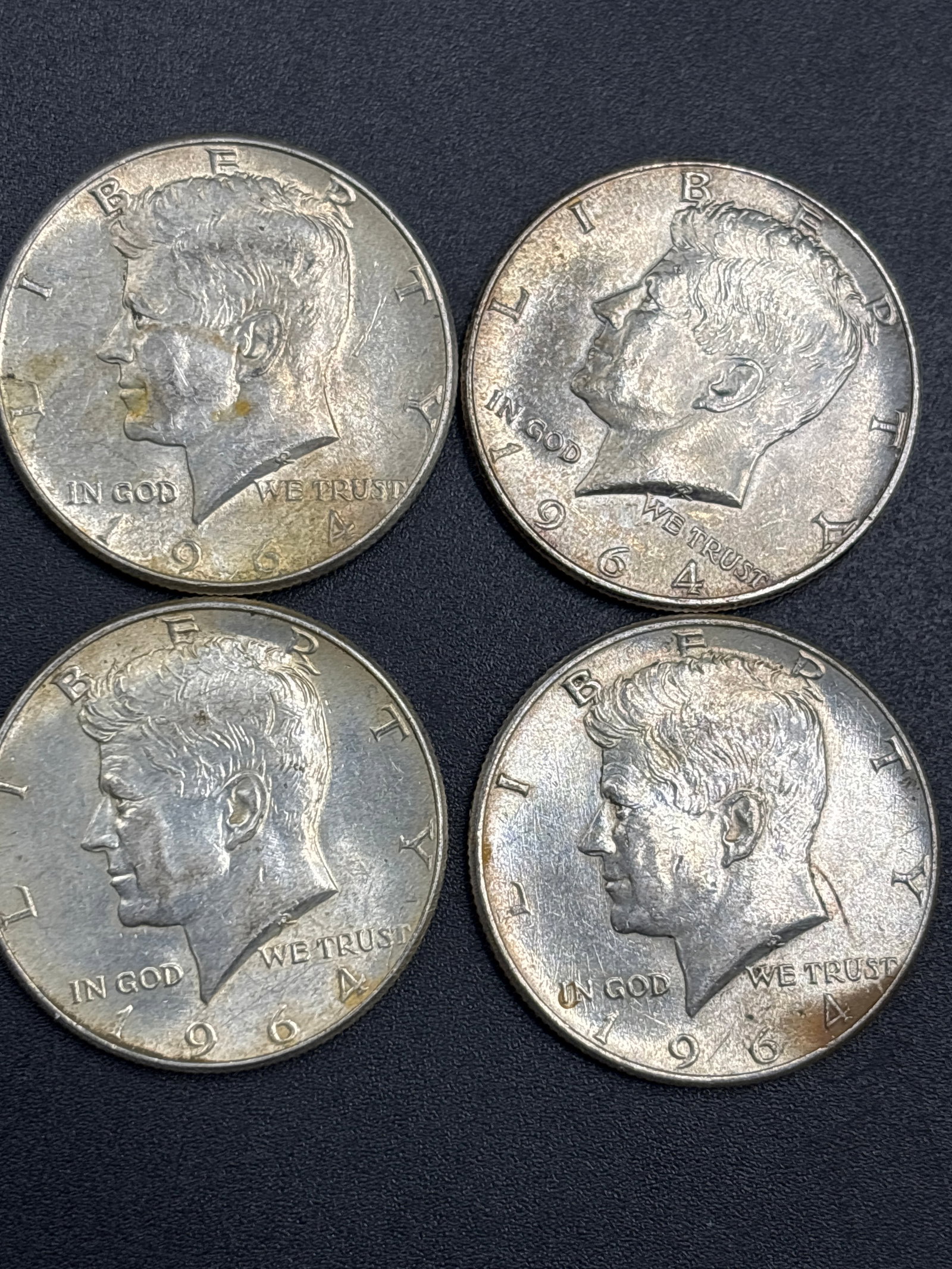 Four 1964 Silver Kennedy US half dollar coins: Four 1964 Kennedy half dollar, marking the first year of the series.It is minted with 90% silver content, which was reduced to 40% in subsequent years.The obverse depicts a profile of President John F