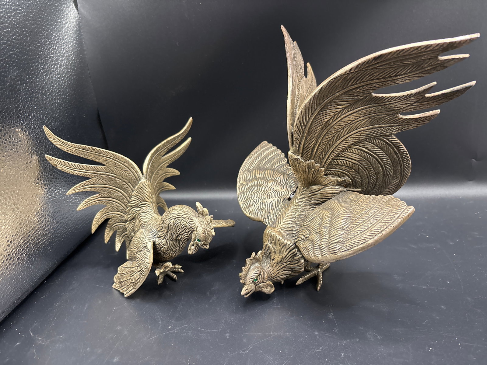 Pair emerald-green jeweled eyes Silvered metal 6 inch statues: Pair emerald-green jeweled eyes makes this pair highly distinct, indicating they are vintage jeweled-eye fighting roosters. Mid-century manufacturers occasionally inset rhinestone, glass, or gemstone 