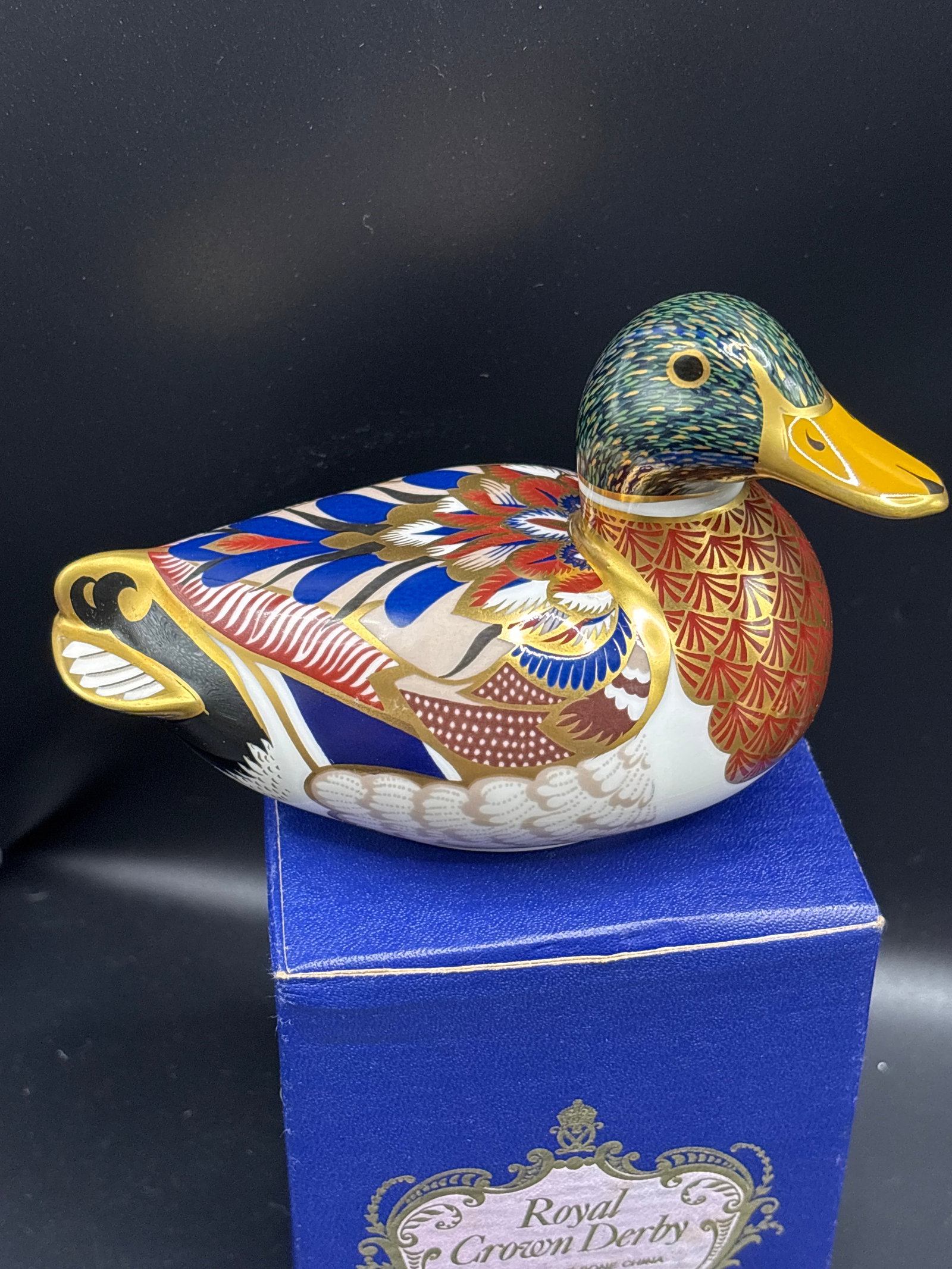 Royal Crown Derby English fine bone china Mallard Duck 5 inch paperweight: Gold stopper with box. Royal Crown Derby Mallard Duck paperweight. Handcrafted in England from fine bone china, it features traditional, highly detailed Imari patterns rich in cobalt blue, deep iron-r