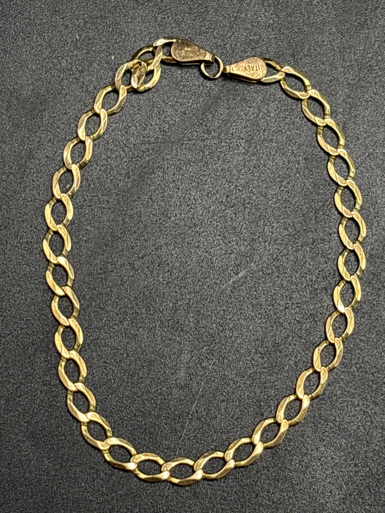 3.21 grams 9 k yellow gold vintage curb link 6 inch chain bracelet: 3.21 grams 9 k yellow gold vintage curb link chain bracelet, characterized by interlocking flat links and finished with a classic lobster clasp closure. This style is often referred to as a Cuban or