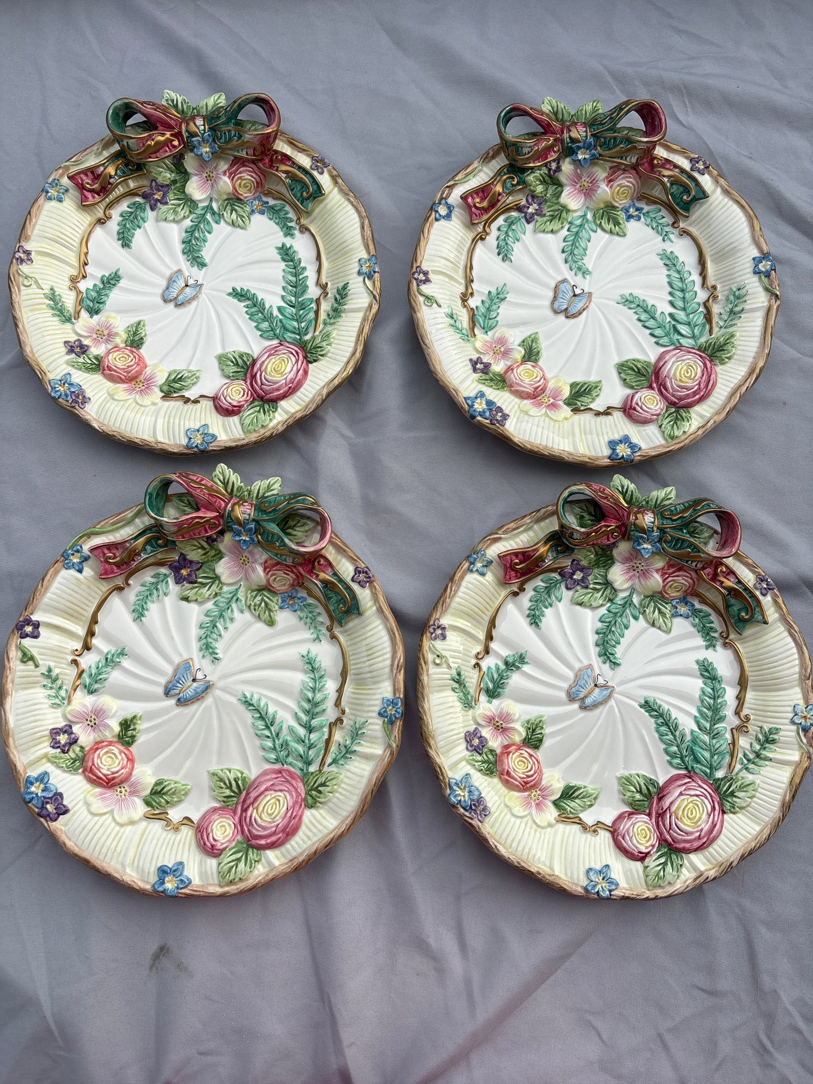 Four vintage Fitz and Floyd "Woodland Spring" decorative plates, 9&1/4 inch: Four vintage Fitz and Floyd "Woodland Spring" decorative plates features high-relief floral and butterfly motifs accented by a whimsical 3-dimensional ceramic ribbon bow. Originally released in the