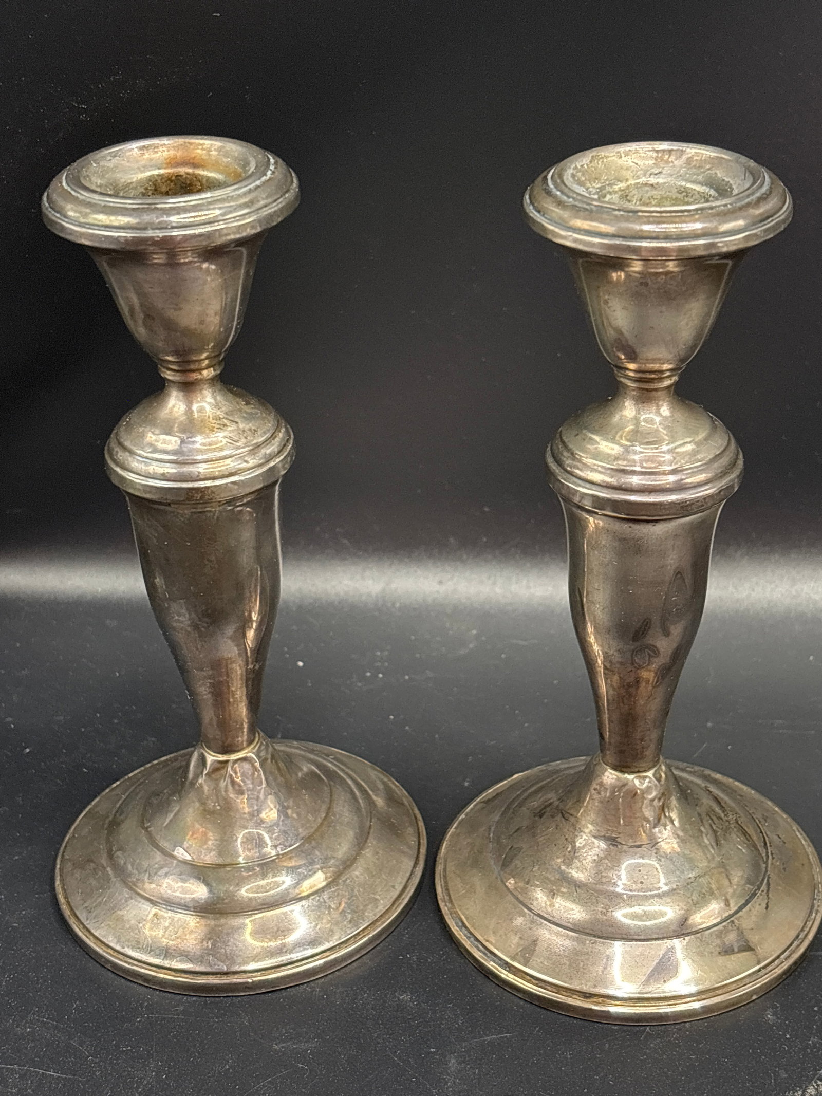 Pair vintage weighted sterling silver 5&1/2 inch candlesticks: Pair vintage weighted sterling silver candlesticks. It features a classic baluster-style stem, a flared sconce lip, and a rounded, stepped base typical of early-to-mid 20th-century traditional
