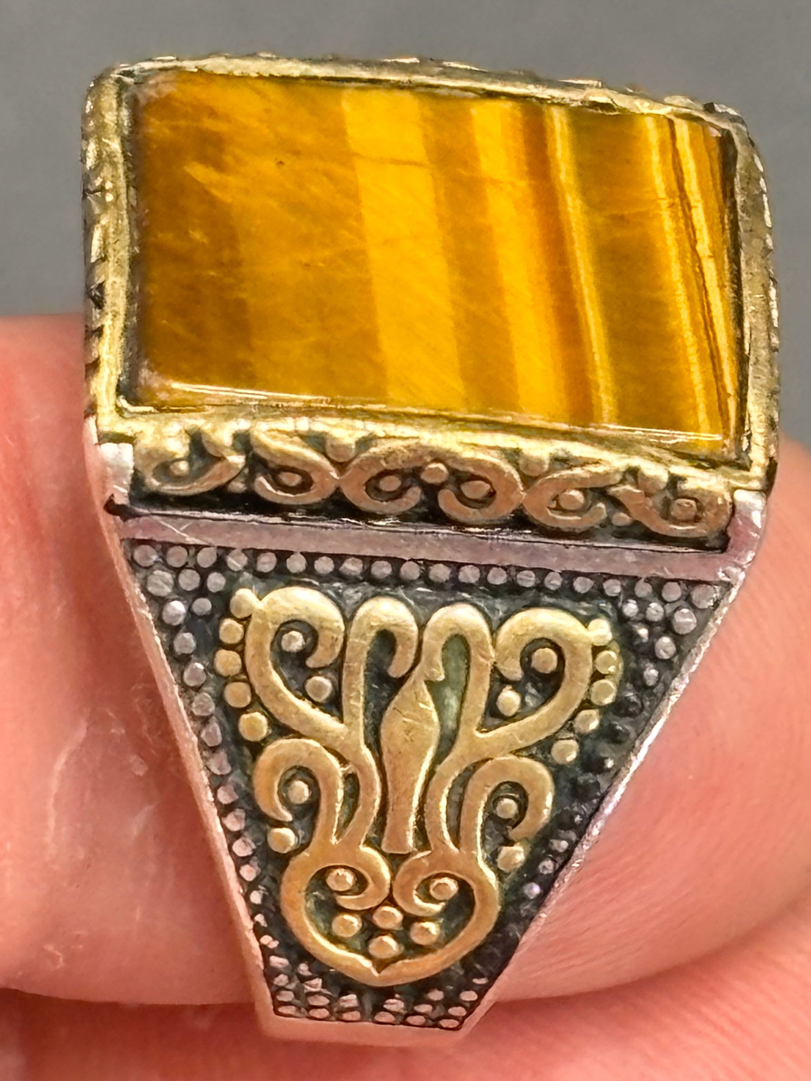 11 grams Sterling men's signet style tiger’s eye ring: 11 grams Sterling men's signet style ring featuring a rectangular or square-cut tiger's eye gemstone.Key Visual CharacteristicsThe Gemstone: The center features a smooth, flat-cut tiger's eye stone.