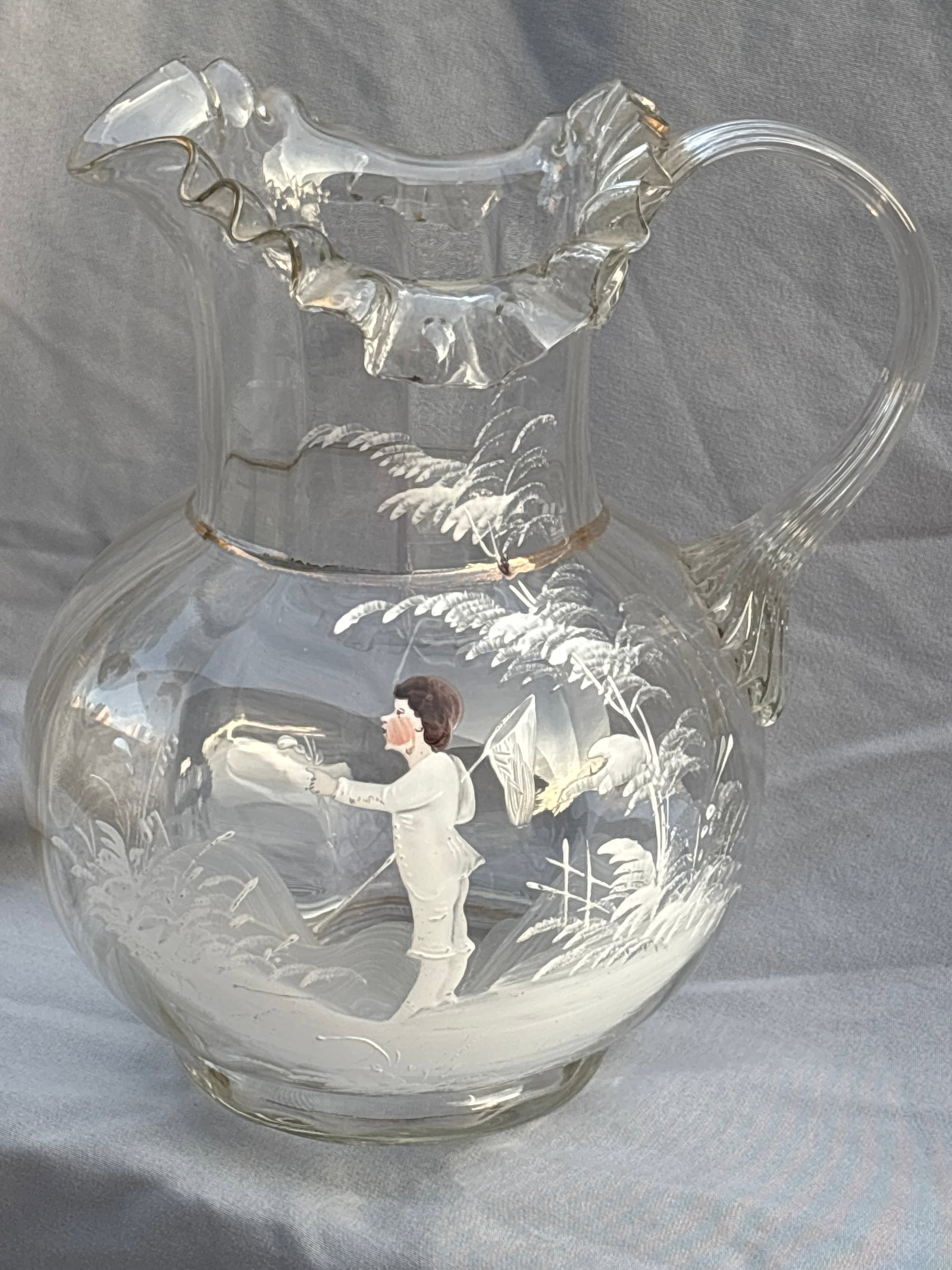 antique Mary Gregory enameled clear art glass 9 inch pitcher: antique clear glass pitcher features a hand-painted enamel scene of a child amidst raised white foliage, characteristic of the Victorian "Mary Gregory" style.Style & Era: Late