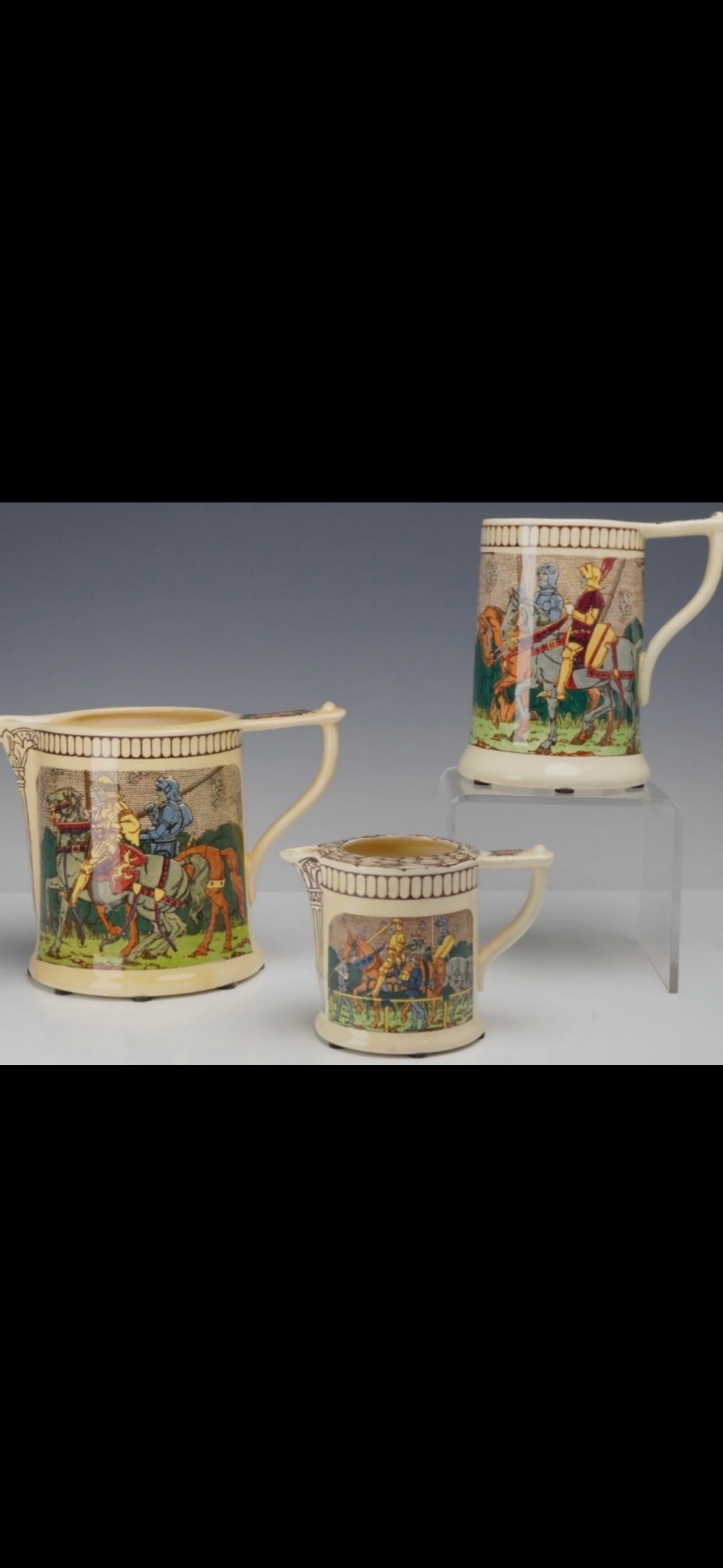 Three antique Royal Doulton Series Ware 'King Arthur's Knights' Pitchers/jugs: large cream-colored ceramic pitcher from the Royal Doulton "King Arthur's Knights" seriesware line (pattern code D2961), featuring detailed multicolor transfers of medieval knights on horseback.Manufa