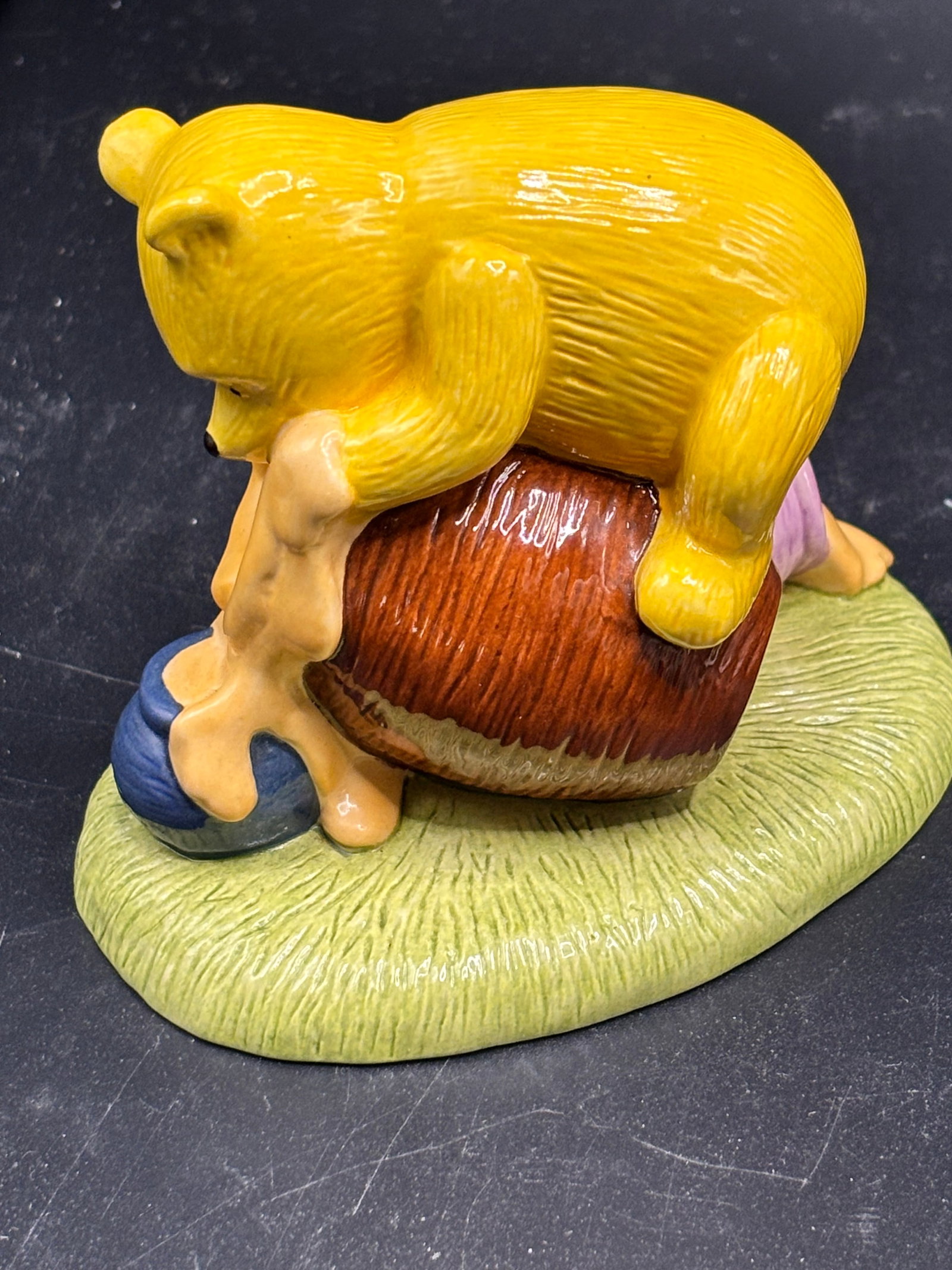 Royal Doulton "Isn't It Funny How a Bear Likes Honey" figurine (model WP60): Royal Doulton "Isn't It Funny How a Bear Likes Honey" figurine (model WP60), featuring Winnie the Pooh reaching into a blue-and-brown honey pot.Released in 2003 as part of the Classic Disney Winnie th