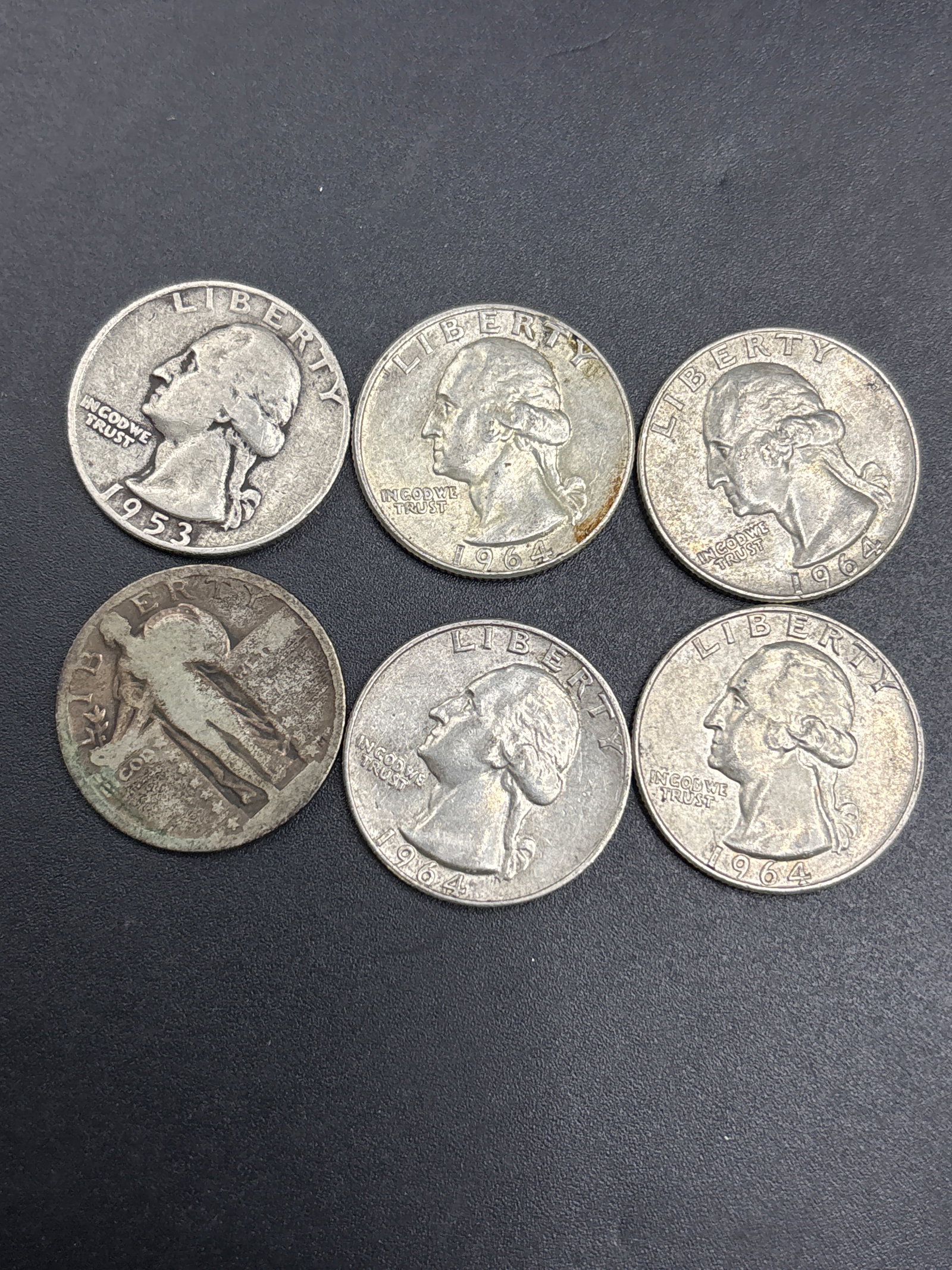 Six silver early quarter dollar coins: Five Washington & One U.S. Standing Liberty Quarter, which was minted between 1916 and 1930. It is made of 90% silver...Four 1964 & a 1953 Washingtons.