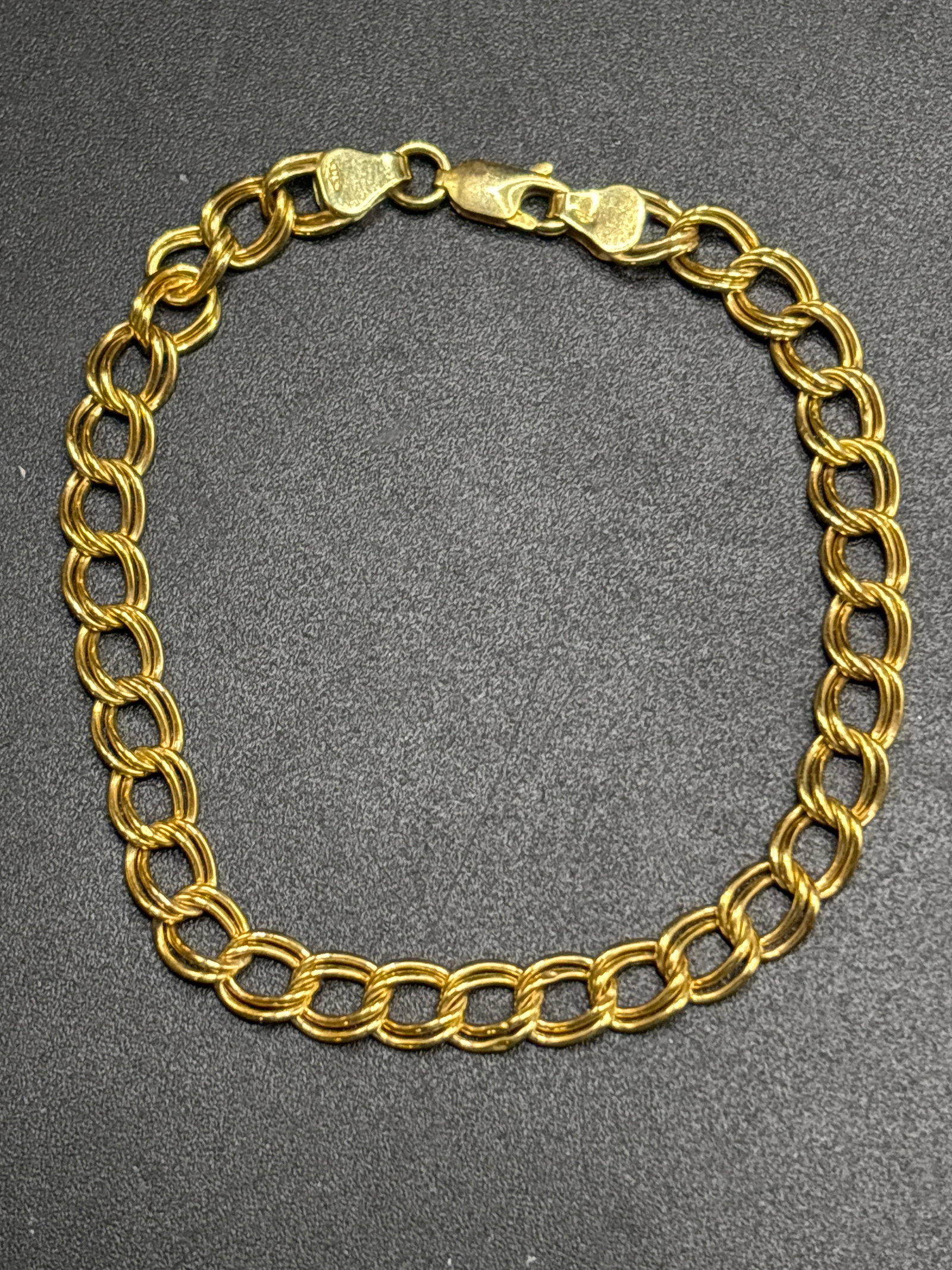 3.06 grams 9 k yellow gold double-link charm bracelet: 3.06 grams 9 k yellow gold double-link charm bracelet featuring a classic parallel interlocking open-wire design and a secure lobster claw clasp.The 9k (9 karat) designation means the metal consists o