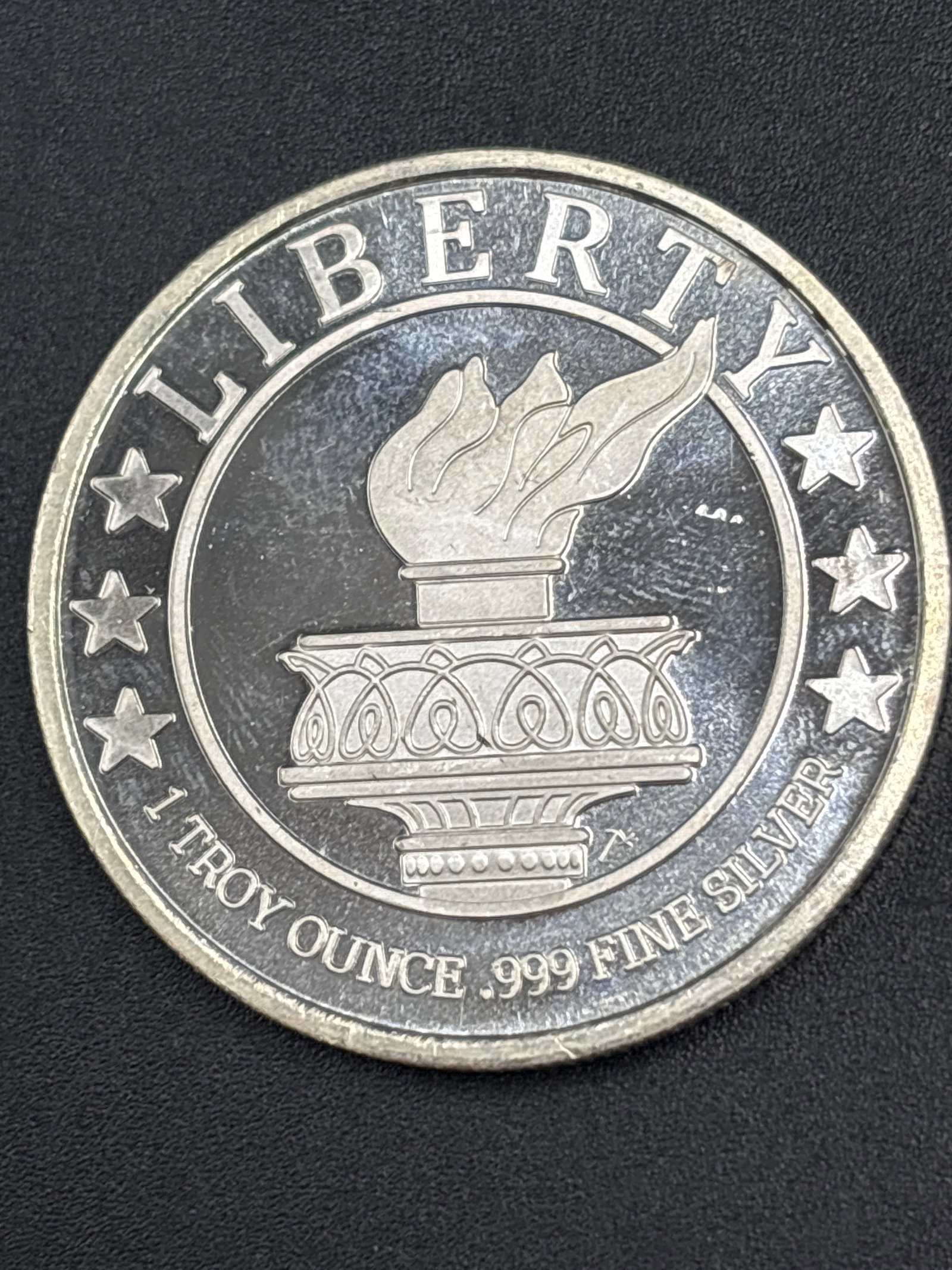 1 troy ounce .999 fine silver SilverTowne Round featuring a Lady Liberty torch: 1 oz. SilverTowne Silver Round featuring a Lady Liberty torch design and stamped with ".999 Fine Silver": Silver bullion round / medallionComposition: Marked as 1 troy ounce of .999 fine silverDesign: