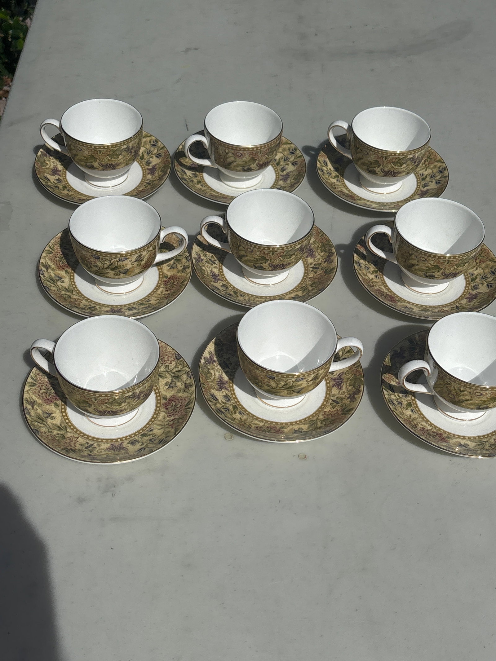 Set of nine elegant tea cups and saucers "Floral Tapestry" pattern by Wedgwood: These elegant cups and saucers feature the "Floral Tapestry" pattern by Wedgwood, a highly detailed fine bone china collection originally produced from 1997 to 2005. The design is recognized by its mu