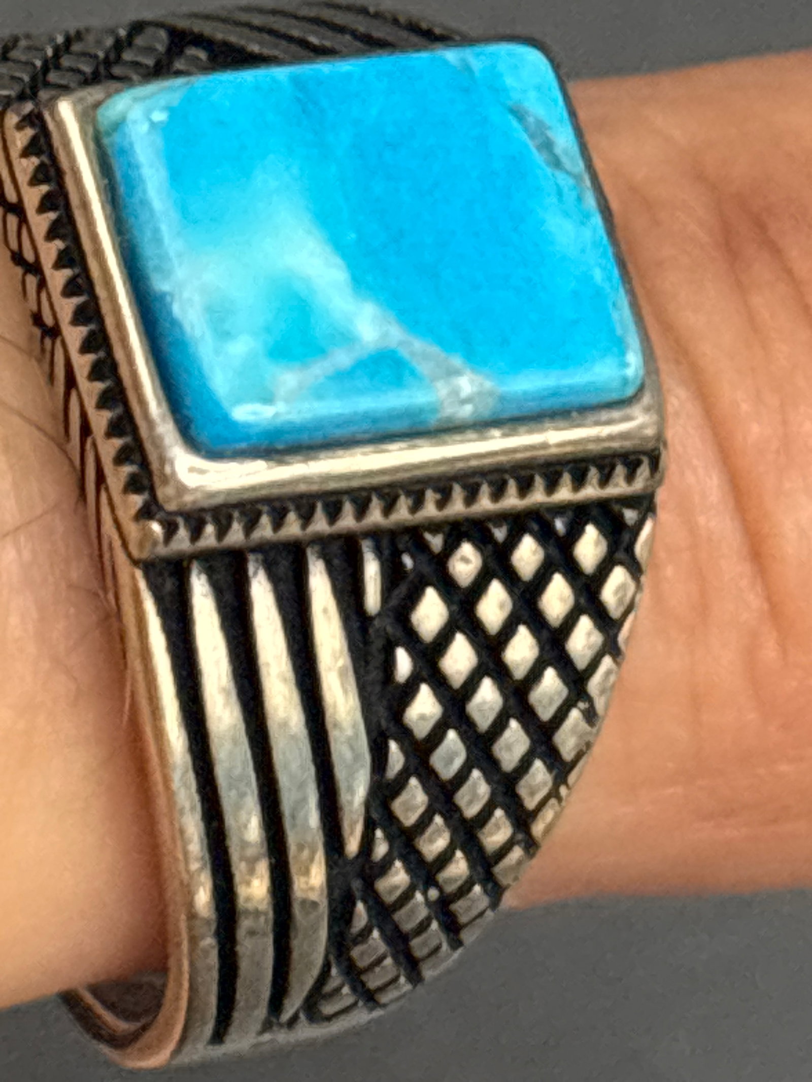 vintage sterling silver signet turquoise center stone ring: Sterling men's vintage-style signet ring featuring a square turquoise center stone, set into a band with detailed geometric and grid-like engravings along the shoulders. Rings featuring this exact tex