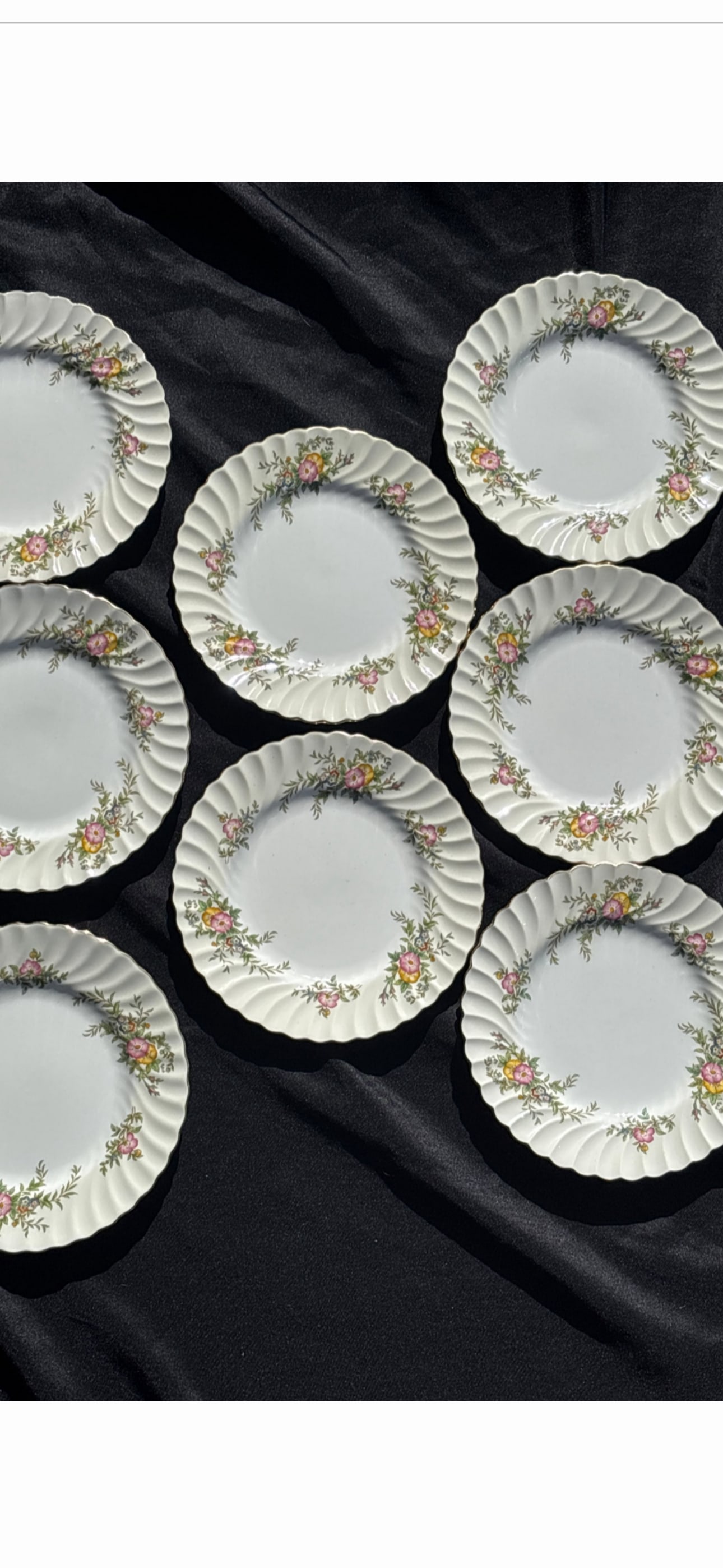 Eight Minton bone china 7&3/4 inch luncheon plates in the "York" pattern (number S501): vintage Minton bone china plates in the "York" pattern (number S501), manufactured in England between 1941 and 1969. Design: Features a swirled rim with pink and yellow floral sprays on a cream-colore