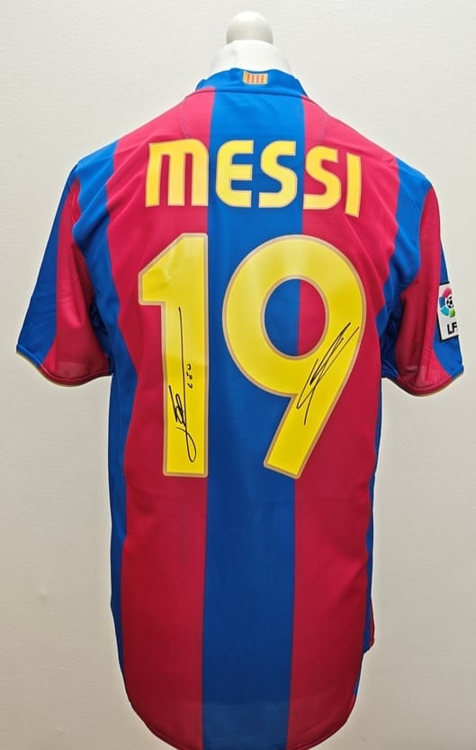 Lionel Messi & Lamine Yamal Signed FC Barcelona 2007-2008 Home Shirt #19 (ICONS Authenticated): FC Barcelona 2007-2008 home jersey, signed by Lionel Messi and Lamine Yamal. The red and blue striped shirt features Messi's name and number 19 on the back, with Messi's signature placed on the number