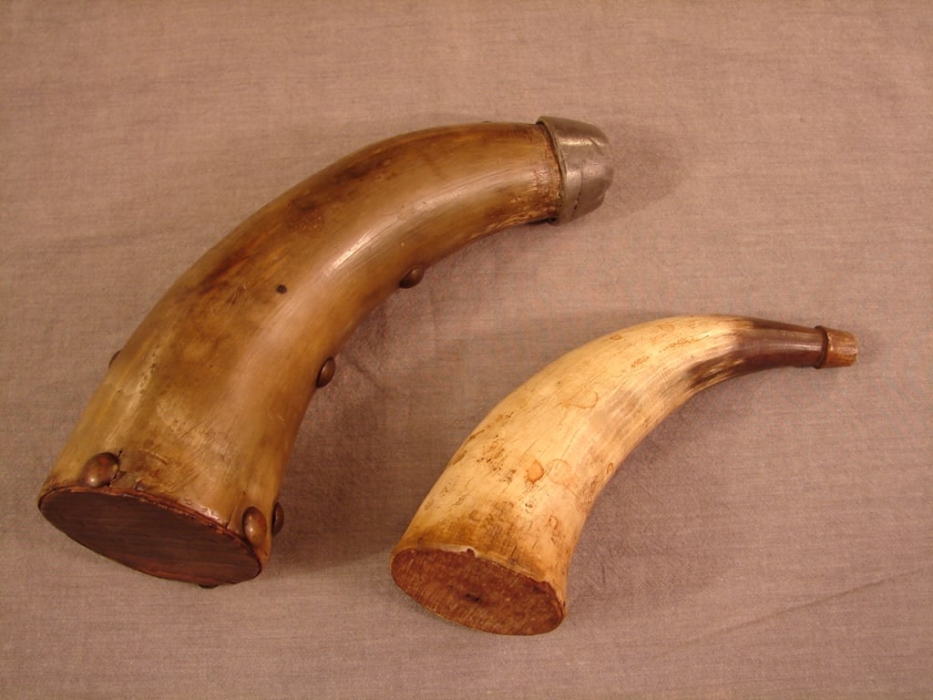 Lot antique powder horns scrimshaw named & dated: Lot 2 antique powder horns. One smaller and one large with unique two compartment spotted horn with lead double spout. The large horn has multiple personal carved scrimshaw with names and date. To the