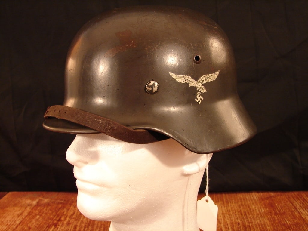 WWII Luftwaffe double decal helmet: WWII Luftwaffe double decal helmet. Marked EF64 with lot number 3765. Tri color decal removed per regulations. Chin strap with a repair but all there.