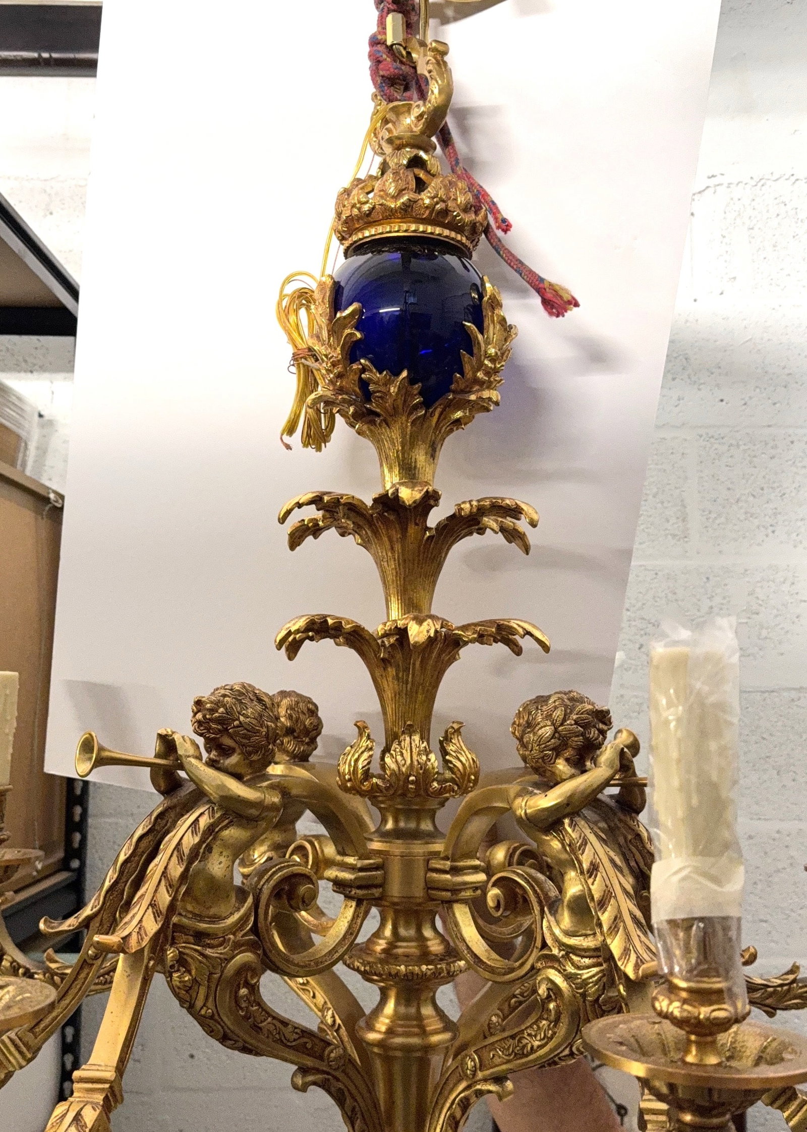 Solid Bronze Louis XVI Style French Chandelier Circa (1890s - 1920s): KEYWORDS: French Antiques, Bronze, Cobalt Blue, Cherub, Putti Figures, Musical Theme, Trumpets, Horns, Candelabra, Chandelier, Neoclassical, Influence, Acanthus Leaf Decoration. Has 8 Arms. Completly