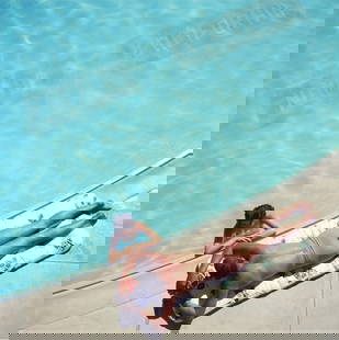 Slim Aarons (American, 1916-2006) Print: Slim Aarons (American, 1916-2006) Print. Lake Tahoe Couple. 40.00 x 40.00 inches. Please be aware that all lots in our auctions are sold "AS IS," in accordance with the Terms & Conditions of the Aucti