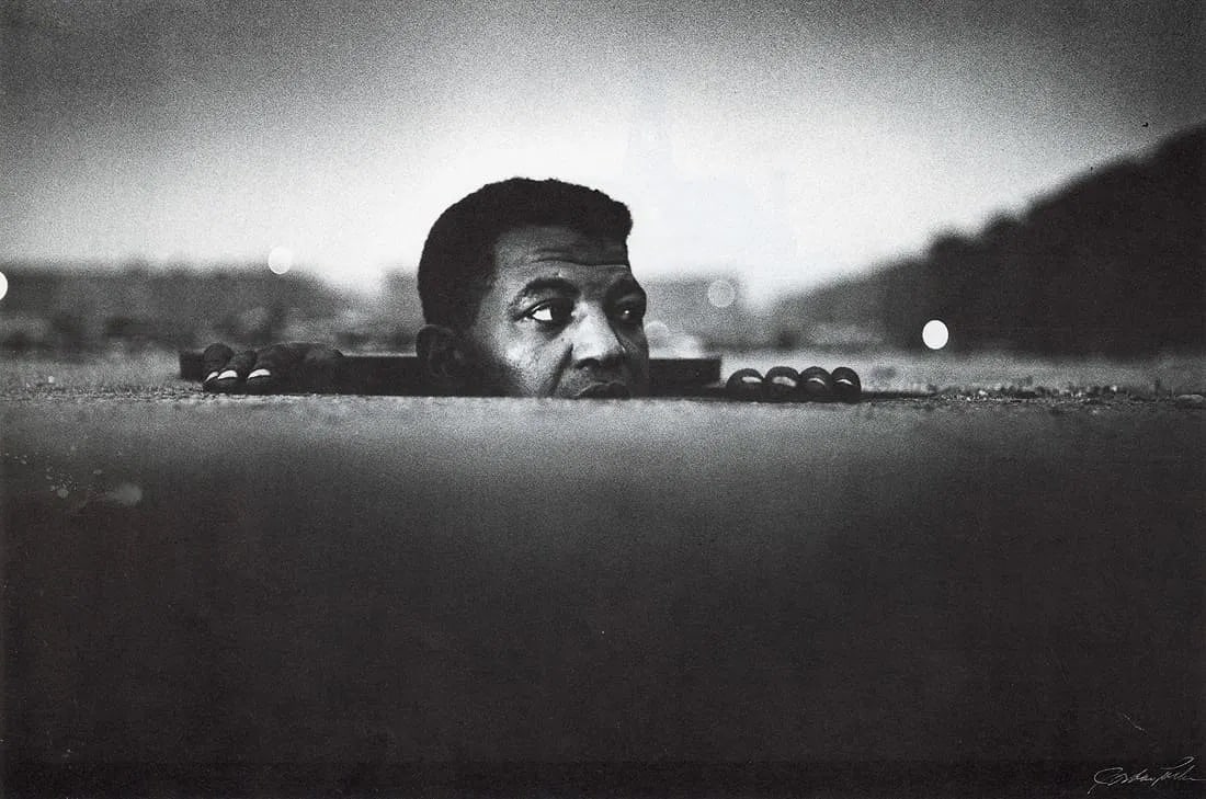 Gordon Parks (American, 1912-2006) Print: Gordon Parks (American, 1912-2006) Print. Man Emerging, Harlem, "1952". Printed in 1983, USA. Duotone. 8.85 x 5.85 inches. Not hand-signed unless otherwise stated. Photomechanical Print. Lots that con
