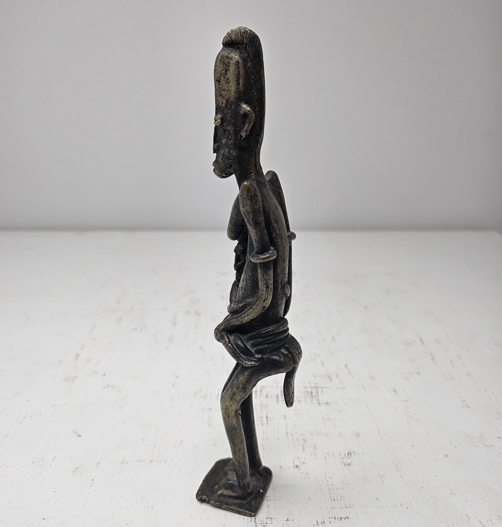 Dogon-Attributed African Patinated Bronze Female Figure Mali Early-Mid 20th C.: Dogon-attributed West African cast bronze or brass female figure, Mali, first half to mid-20th century. The standing figure is rendered in a highly stylized elongated form with a tall coiffure or head