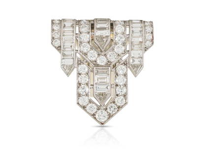 Art Deco 1930s 7.00 Carat Diamond Clip: Finely crafted in platinum with 30 Old European cut Diamonds weighing approximately a total of 5.40 carats, 20 Baguette cut Diamonds weighing approximately a total of 1.20 carat, and 4 Trillion cut Di