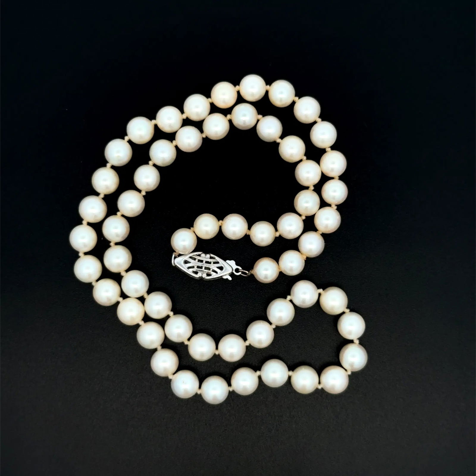 14k WG White Pearl Necklace: Classic white pearl necklace in 14k white gold featuring 6.50mm pearls, a timeless strand ideal for formal or everyday elegance. - Pearls approx. 6.50mm diameter - Length: approx. 16.5 inches - Total