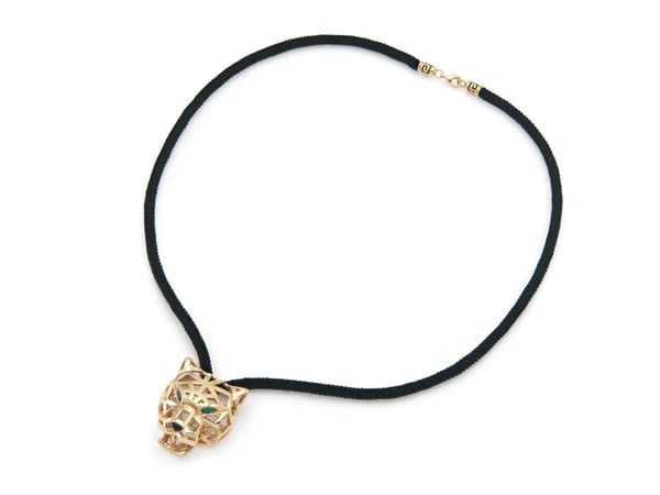 18k Rose Gold Panther Emerald Pendant: Panther head pendant necklace crafted in 18k rose gold with emerald eyes and black onyx nose, suspended from a 20.5-inch black cord. - Panther head motif in solid 18k rose gold - Two pear-shaped emera