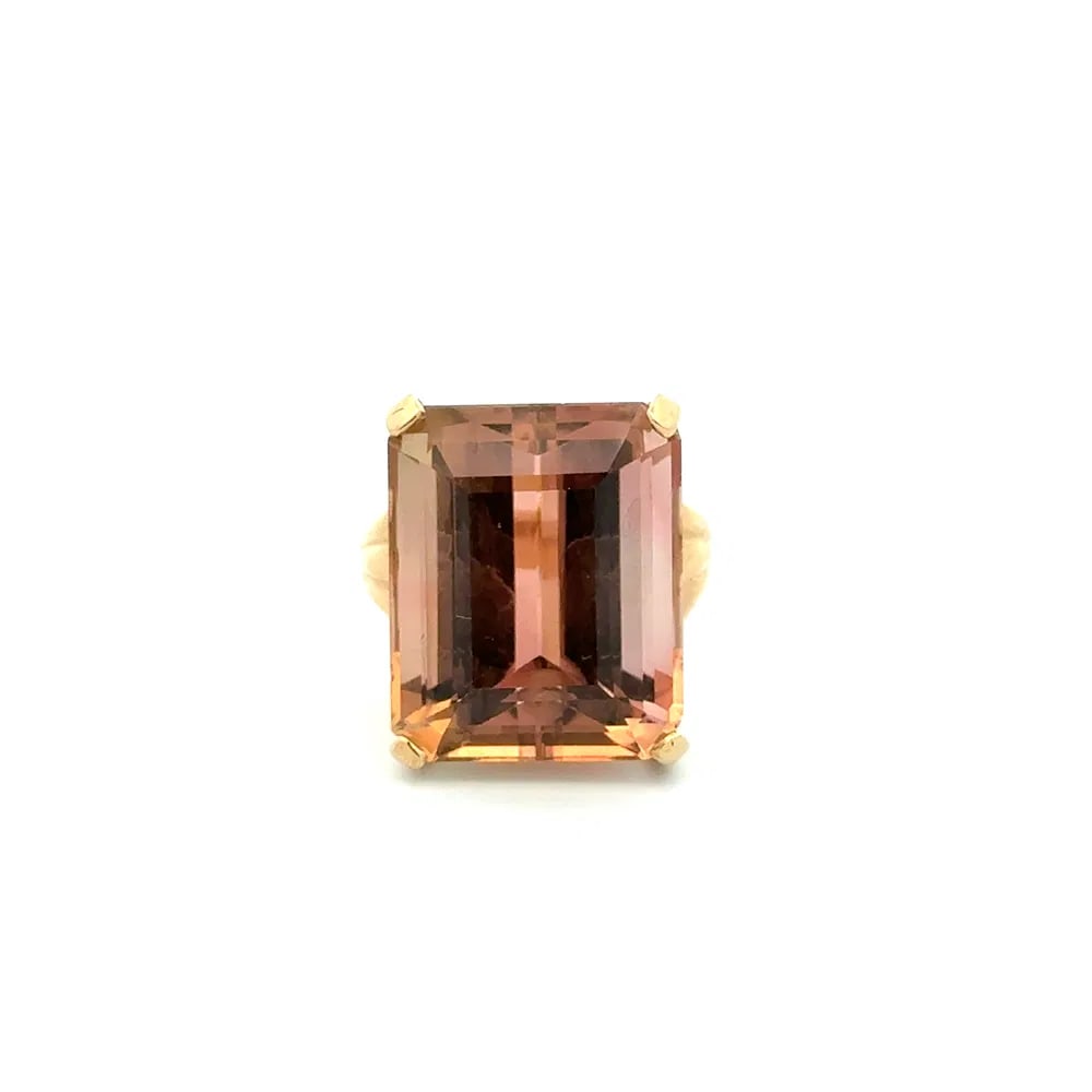 14k Gold 20ct Peach Tourmaline Ring: Bold solitaire ring showcasing a 20ct orangy peach emerald cut tourmaline set in rich 14k yellow gold, a vibrant modernist statement piece with timeless appeal. - Center: Orangy peach tourmaline, emer