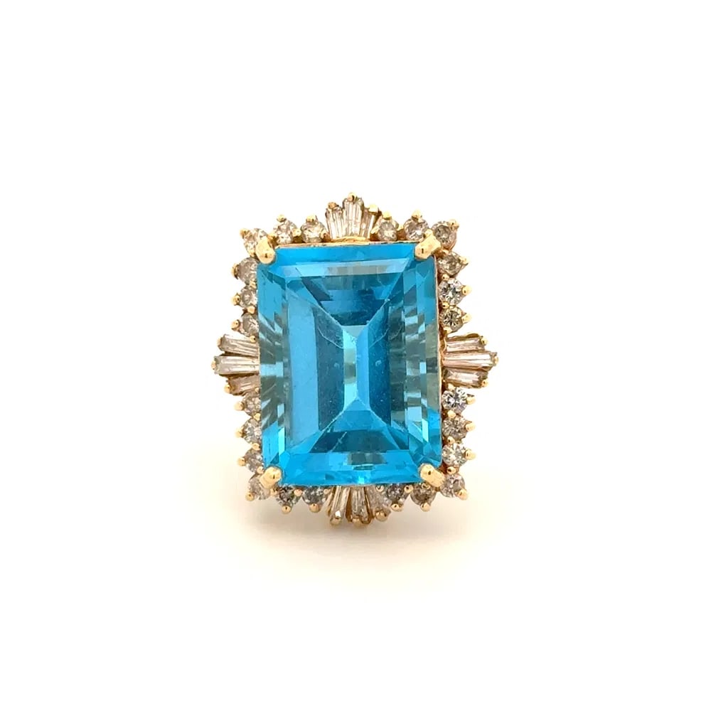 14k Gold 20ct Blue Topaz Diamond Ring: Massive cocktail ring in 14k yellow gold showcasing a striking 20ct emerald cut blue topaz and 1.10tcw of diamonds, a statement piece with substantial presence. - Center: Blue topaz, emerald cut, appr