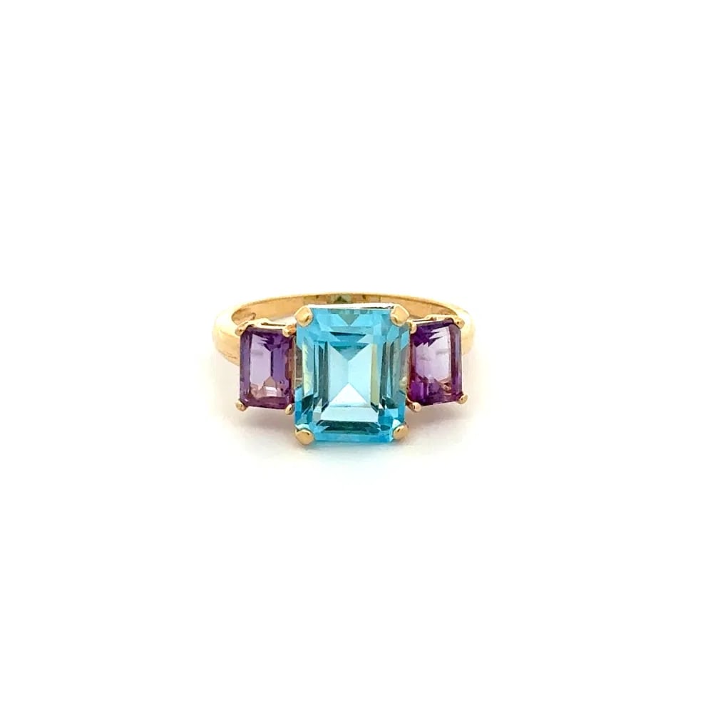 14k Gold Blue Topaz Amethyst Ring: Contemporary ring in 14k yellow gold featuring a 2.50ct emerald cut blue topaz and 1.00tcw of amethyst, a vibrant and stylish design perfect for colorful gemstone collectors. - Center: Blue topaz, eme