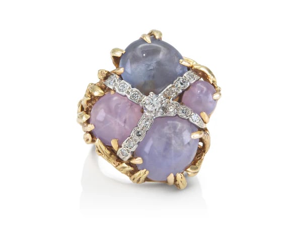 1950s Gold Purple Star Sapphire Ring: Vintage 1950s cocktail ring crafted in 14k yellow and white gold with four purple star sapphires totaling approx. 8.00ct and diamond accents, a bold mid-century treasure. - Four cabochon purple star s