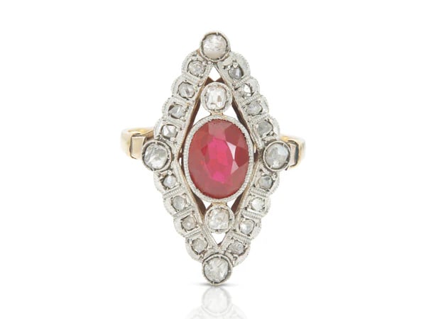Edwardian Platinum Gold Ruby Navette Ring: Antique Edwardian navette ring crafted in platinum over 14k yellow gold featuring a vivid synthetic ruby and sparkling rose cut diamonds, circa early 1900s. - Synthetic ruby center in elongated navett