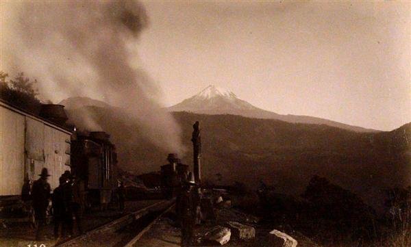 OTIS M. GOVE (American) Vintage albumen print: Otis M. Gove (American, 1851 - 1931). "Down the Vera Cruz Road. Mount Orizaba in Distance [Mexico]". Vintage albumen print. c1880. Printed 1880. Numbered 110 in negative. 4 3/8 x 7 1/4 in. (111 x 184 