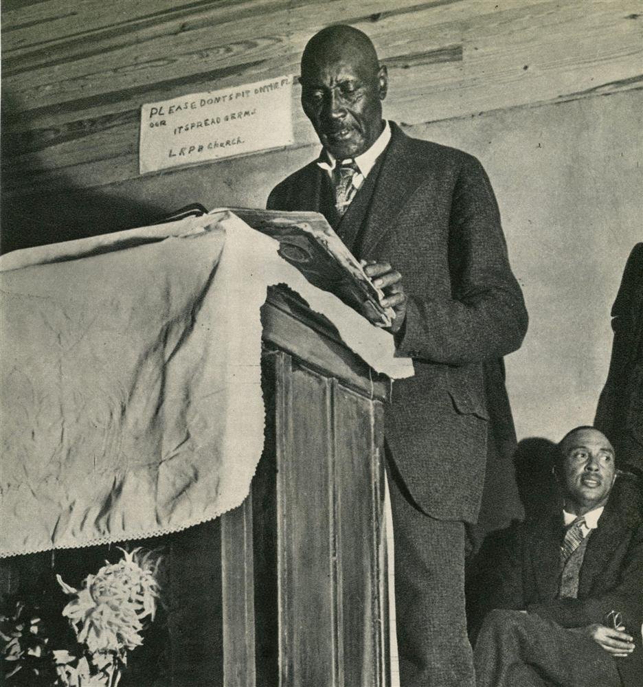 MARGARET BOURKE-WHITE - Original vintage photograv: Margaret Bourke-White (American, 1904 - 1971). "Sunday Sermon, College Grove, Tennessee". Original vintage photogravure. c1936. Printed 1937. Very good condition. The sign on the wall reads: "Please d