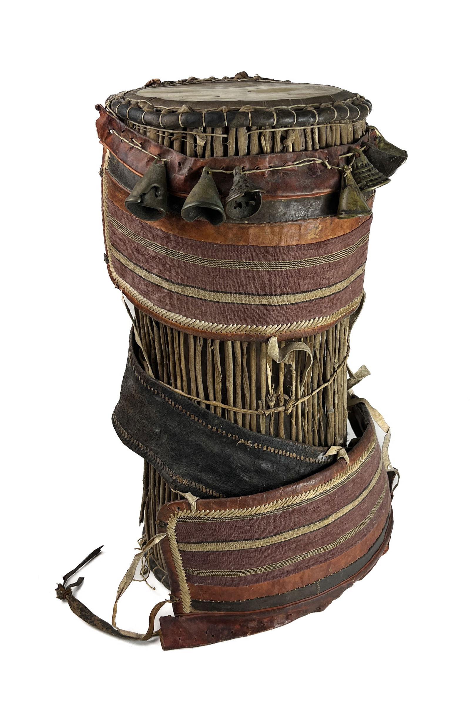 A RARE AFRICAN DUN DUN DRUM, YORUBA, NIGERIA: A RARE AFRICAN DUN DUN DRUM, YORUBA, NIGERIA49 CM HIGH23 CM DIAMETER* Hand Cast Metal Bells* Decorative Fabric and Leather* Leather and Decorative Leather Shoulder Strap* 2 Drumheads connected by leat