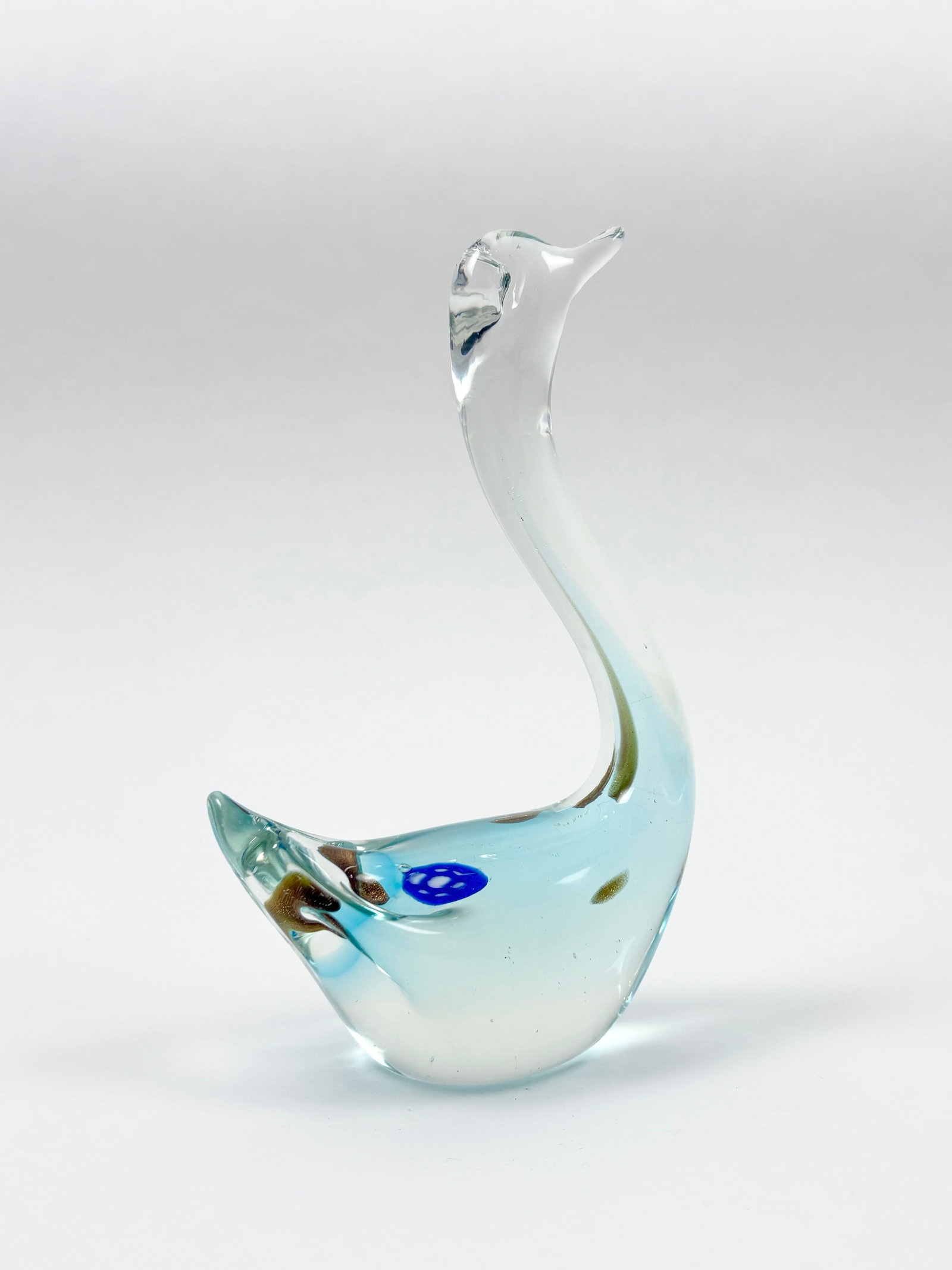 Murano Art Glass Swan Sculpture, 6.75 Inches: MURANO Art Glass style Swan Sculpture Delicately crafted in the Murano glass tradition, this swan sculpture showcases a beautiful gradient of translucent aqua blue to clear with internal decorative bu