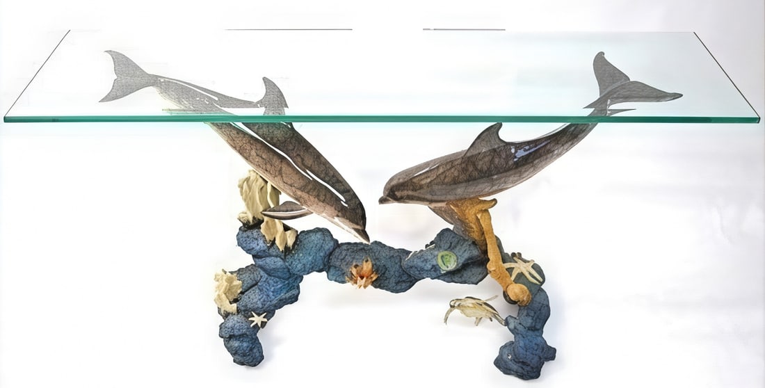 Robert Wyland Signed Dolphin Arch Entry Table w/ Glass Top: Robert Wyland, Dolphin Arch Entry Table A striking sculptural entry table by renowned marine artist Robert Wyland, featuring two leaping dolphins forming an arch, surrounded by detailed sea life and c