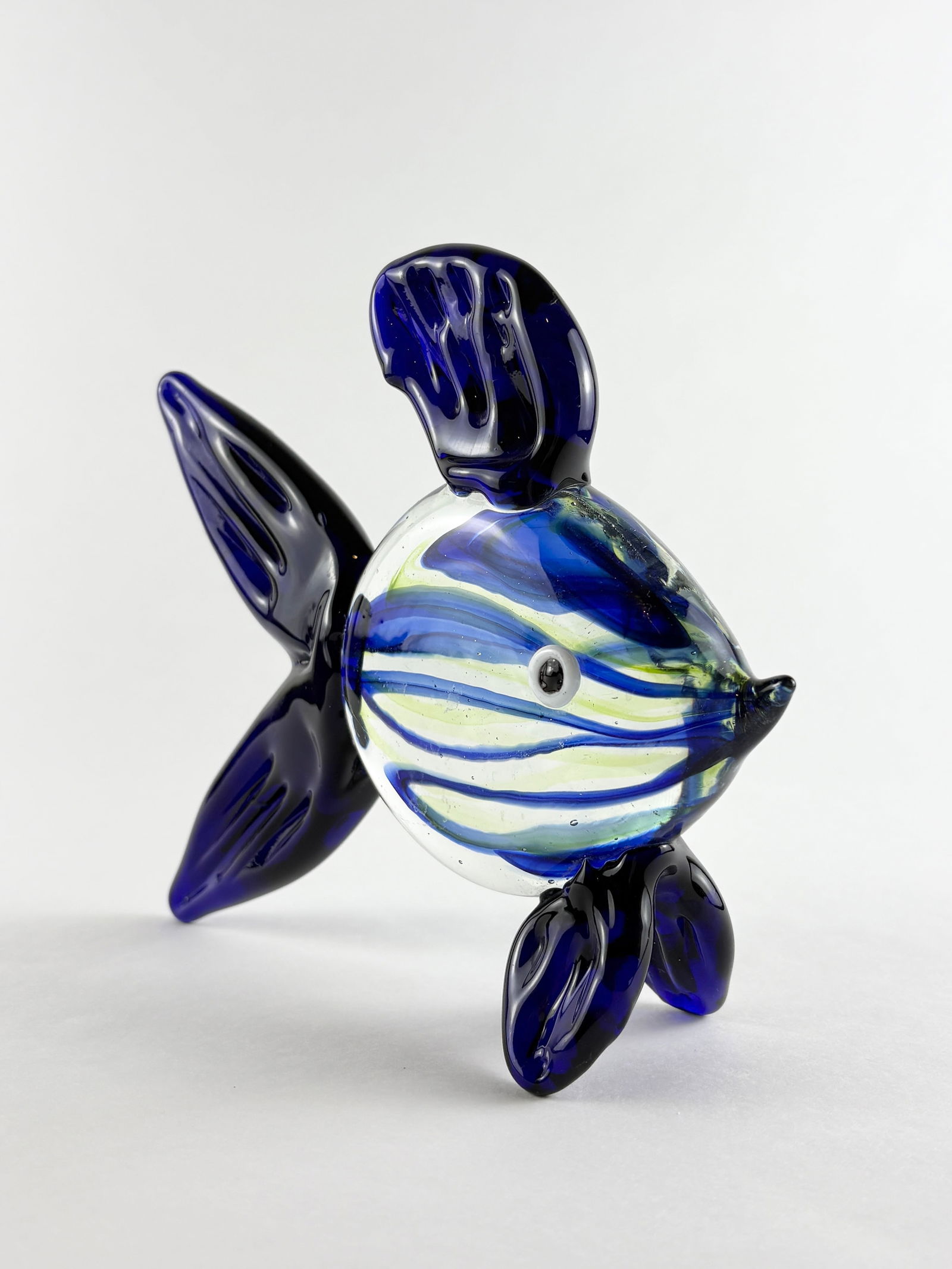 Murano-style Art Glass Fish: Art Glass Fish, Glass Fish Glass Height: 6 inches A decorative art glass fish in the style of Murano, featuring blue and white striping. One glass fish is included.