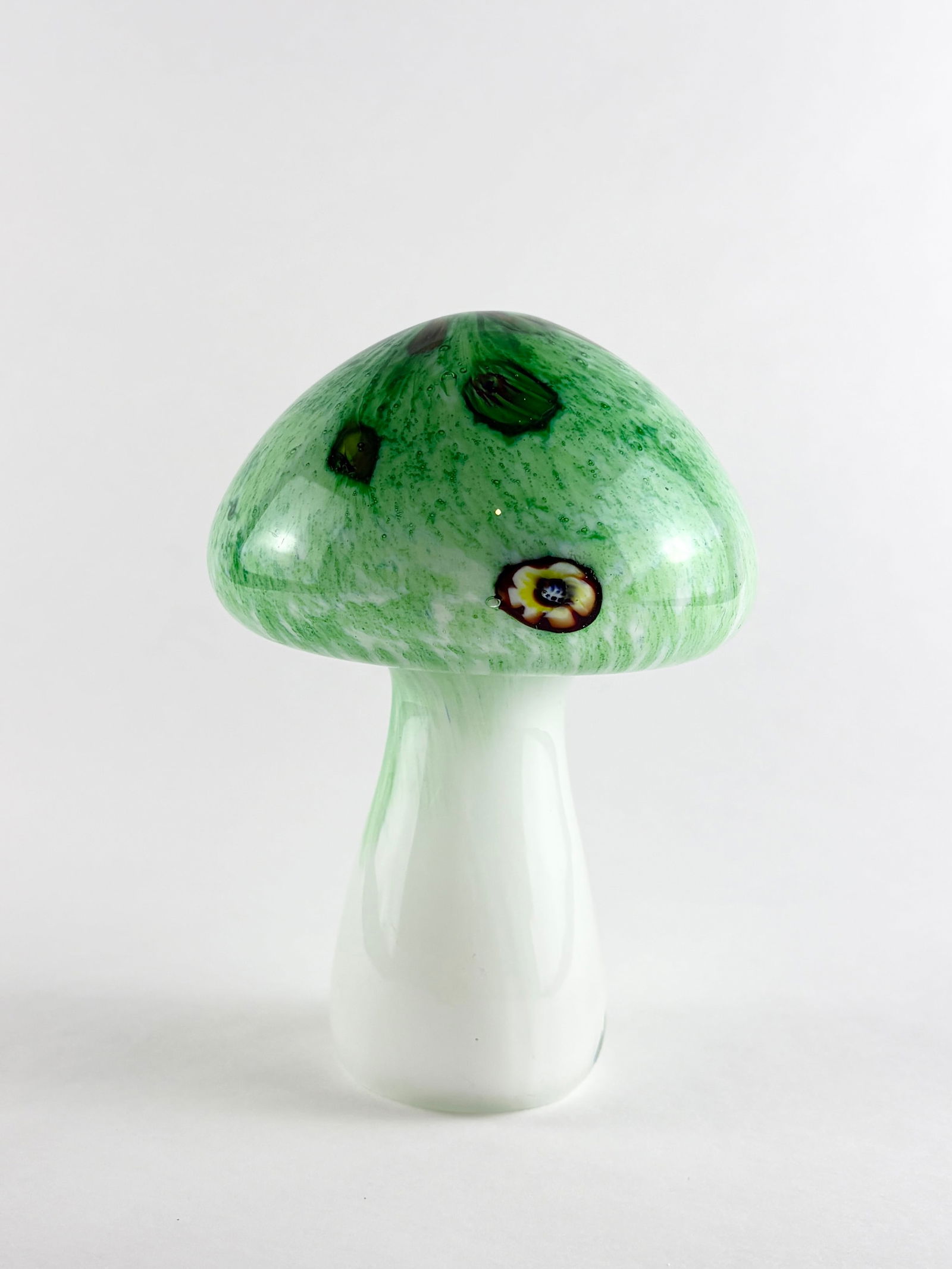 Art Glass Mushroom: Art Glass Mushroom, Glass Mushroom Glass Height: 5 inches A decorative art glass mushroom with a green cap and white stem.