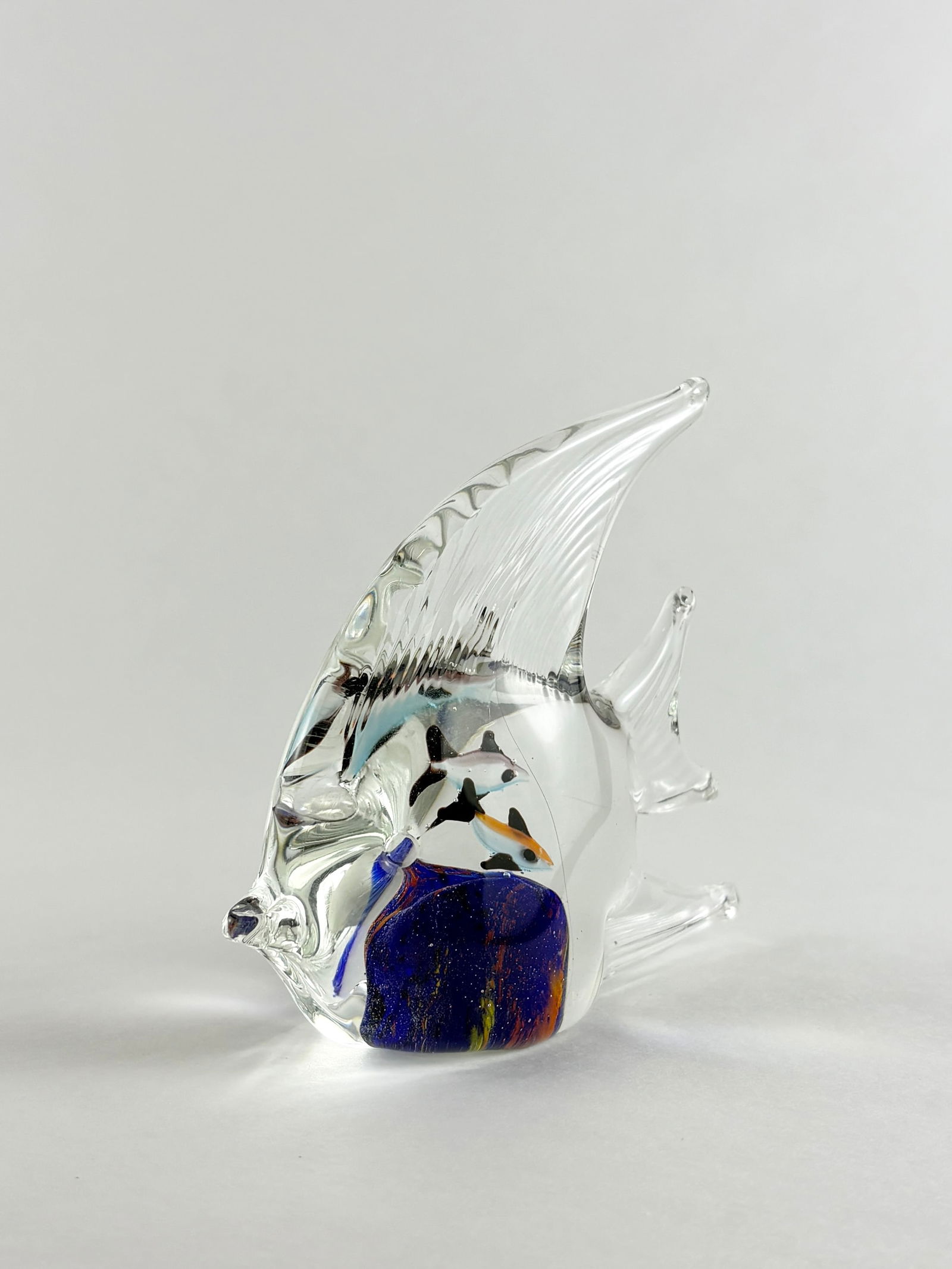 Art Glass Fish, Murano Style: Art Glass Fish, Murano Style Glass Fish Glass Height: 4 inches A decorative art glass fish with clear fins and a blue and multicolored internal form.