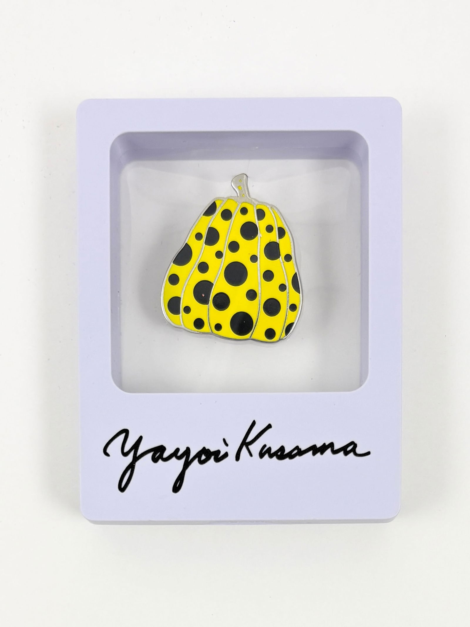 Yayoi Kusama Enamel Pin: Yayoi Kusama Enamel pin on metal Enamel pin featuring a pumpkin form decorated with Kusama’s signature polka-dot motif. Presented in the original branded display packaging bearing the artist’s