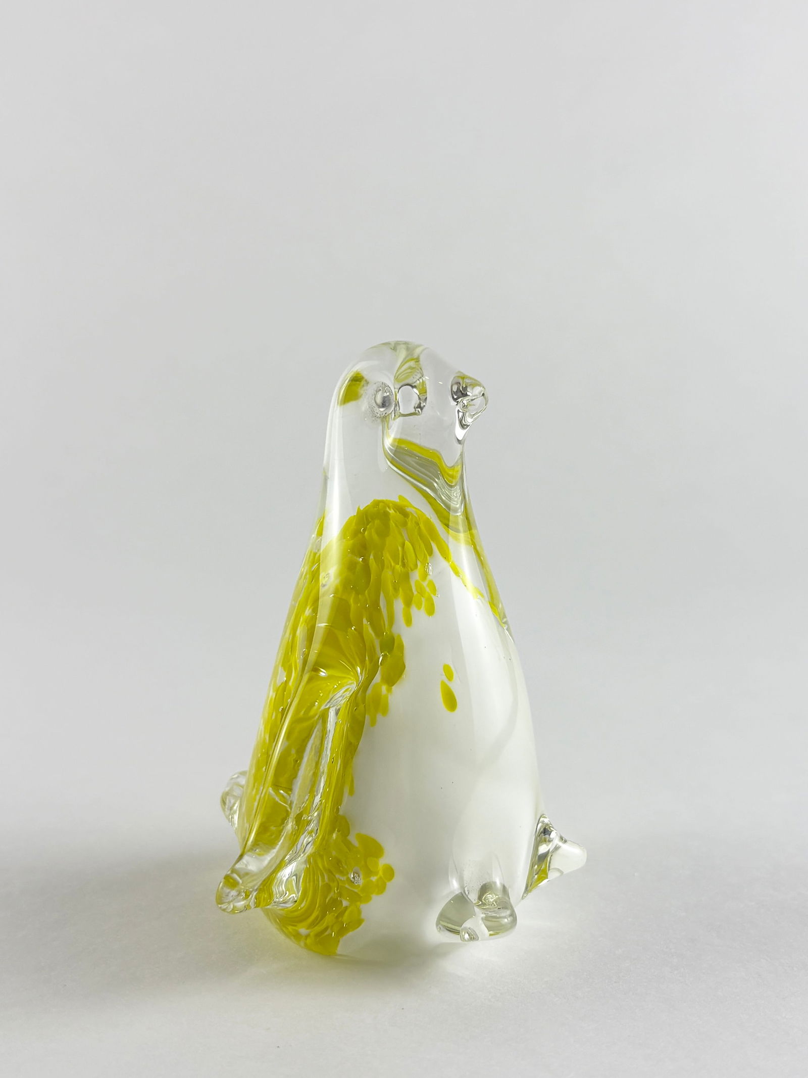 Glass Penguin Sculpture, Murano Style: Clear and yellow art glass sculpture Handblown glass penguin featuring a clear body with vibrant yellow interior accents. The figure is rendered in a simplified, upright form with applied details and