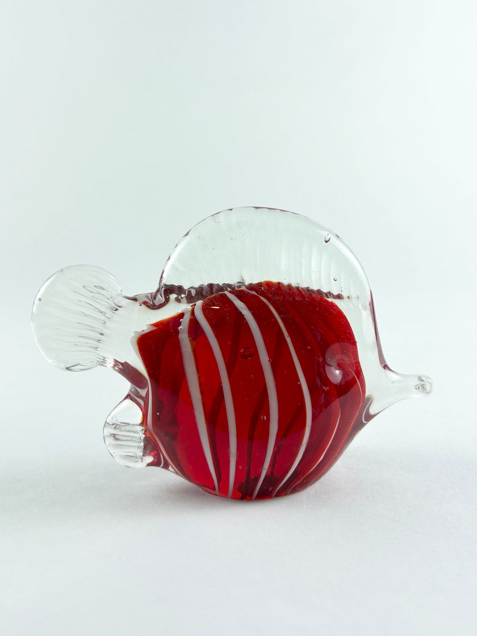 Glass Fish Sculpture (Murano Style): Decorative art glass fish sculpture featuring a vivid red body encased in clear glass with applied white trailing decoration. The form is modeled with rounded proportions, extended fins, and a stylize