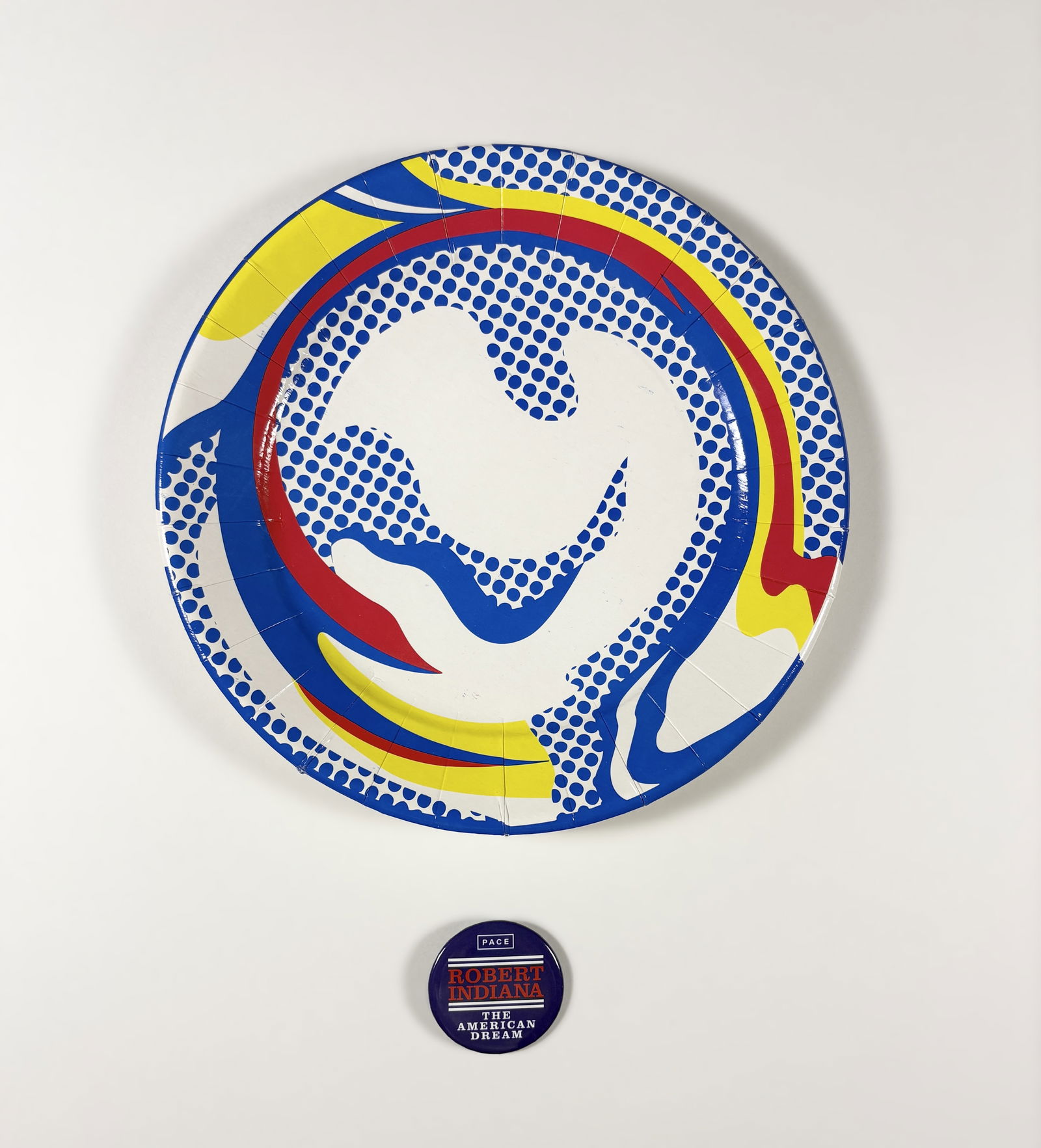 Robert Indiana / Roy Lichtenstein – Pace Button and Barneys Plate: Robert Indiana / Roy Lichtenstein Pace Button and Barneys Plate pin and paper plate dimensions vary This lot comprises two pop art–related objects: a round Pace Gallery promotional pin featuring