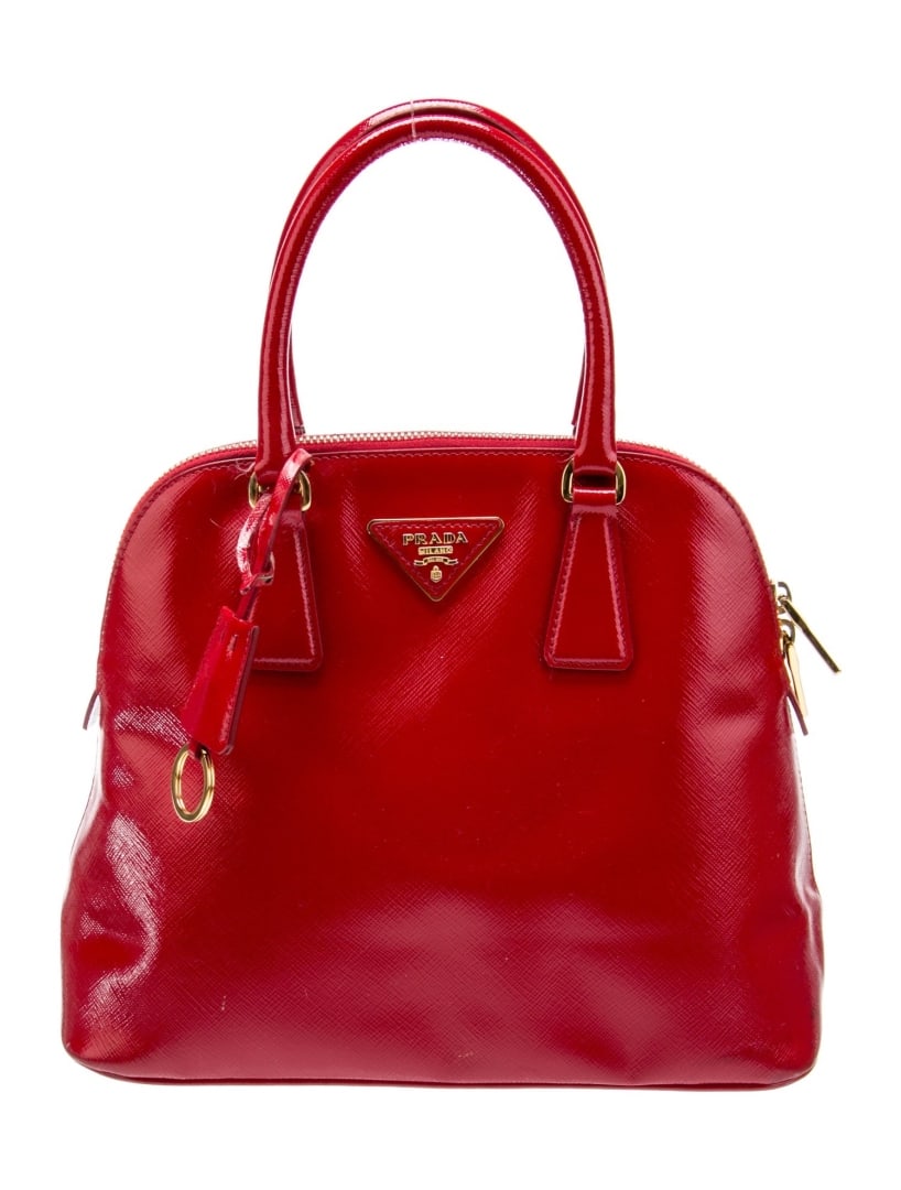 Prada Rosso Saffiano Leather Top Handle Bag: Condition is Very Good, pre-owned. Details: Rosso Saffiano Vernice Leather, Enameled Metal Triangle, Gold-Tone Hardware, Rolled Handles, Single Adjustable Shoulder Strap, Logo Jacquard Lining, Dual In