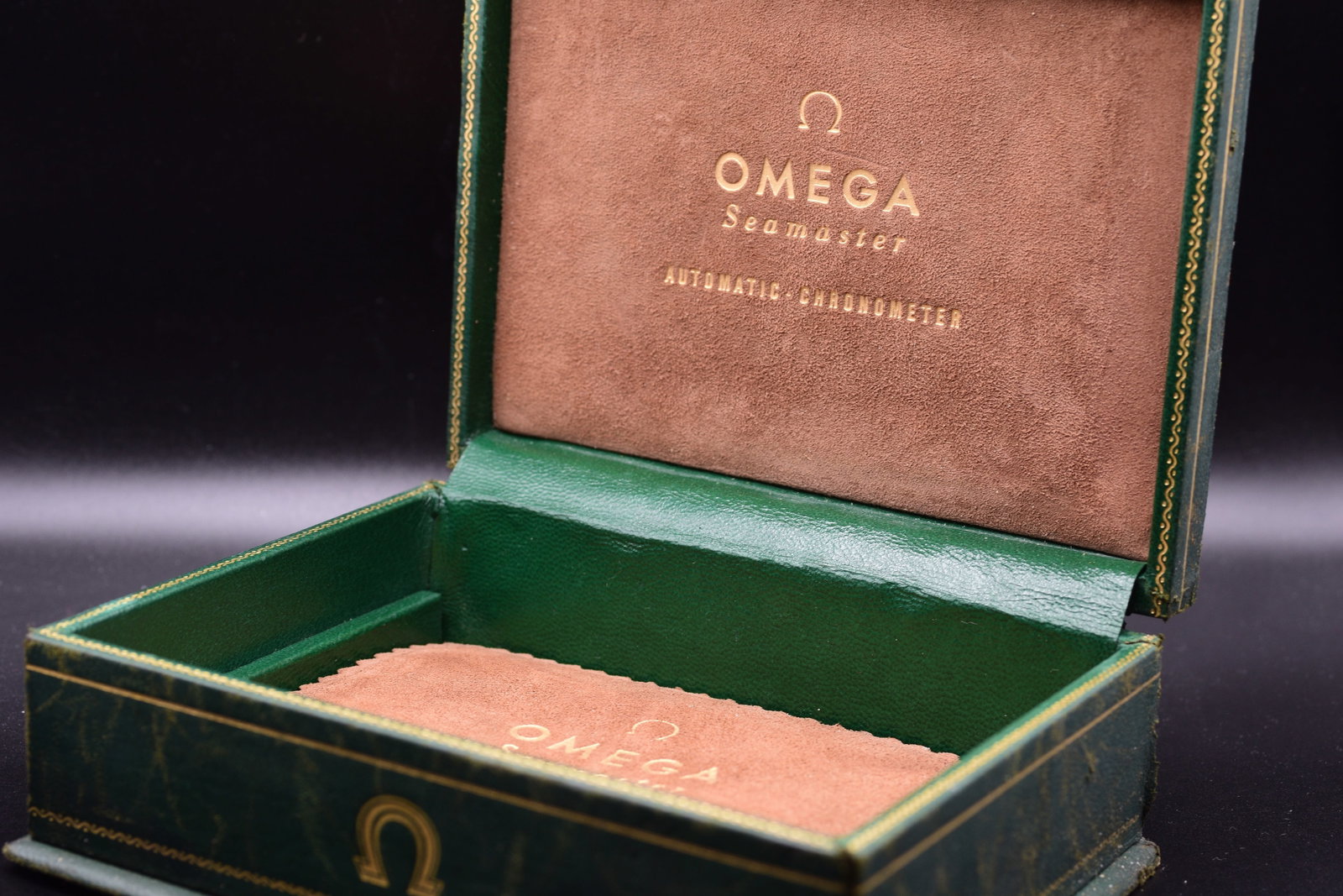 Omega Seamaster Green Leather & Suede Watch Box c.1960s: Omega Seamaster Green Leather & Suede Watch Box c.1960sOmega Seamaster presentation box dating from the mid-1960s, featuring a distinctive green faux-leather exterior with elegant gold-tone