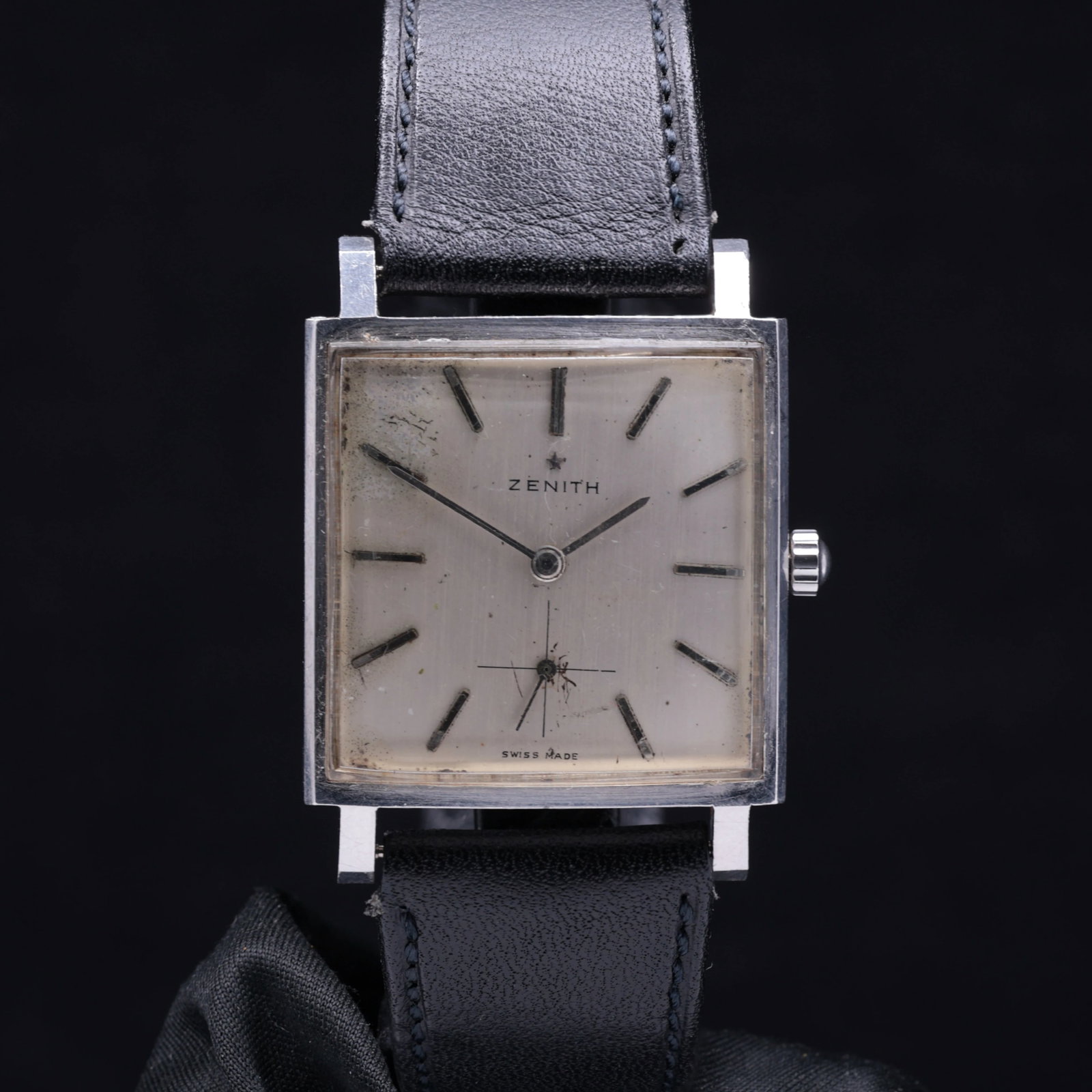 Zenith Square Circa 1960s Stainless Steel Silver Sunburst Dial Patina: Title: Zenith Square Circa 1960s Stainless Steel Silver Sunburst Dial Patina Catalogue Description: A square stainless steel manual wind wristwatch. The silver sunburst dial shows a prominent aged pat