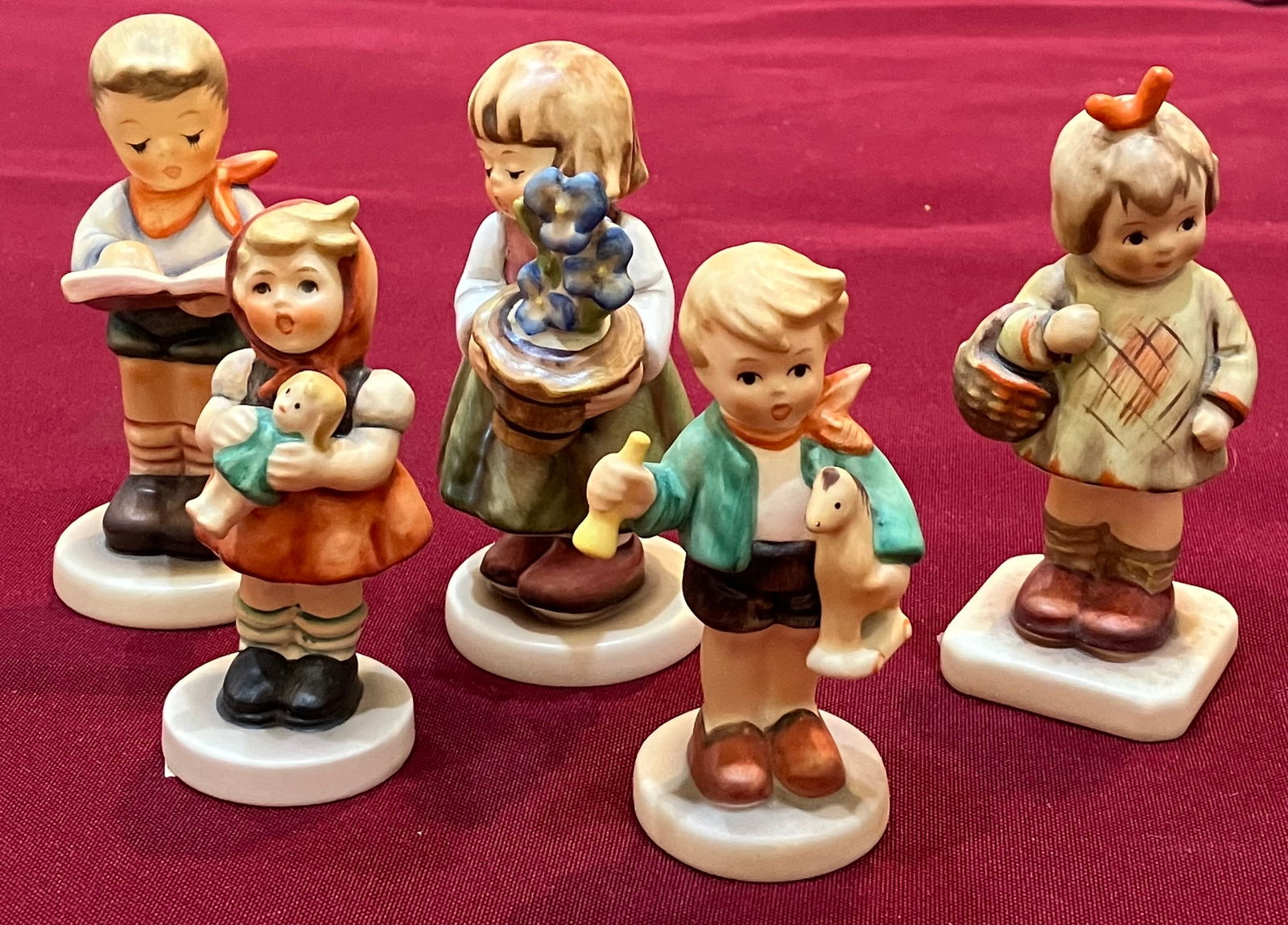 Five Assorted Collectible Goebel Hummels - 'Girl with a Doll', 'Boy with a Horse', 'Honor Student',: Five Assorted Collectible Goebel Hummels - 'Girl with a Doll', 'Boy with a Horse', 'Honor Student', 'I Brought You a Gift', 'Birthday Present'